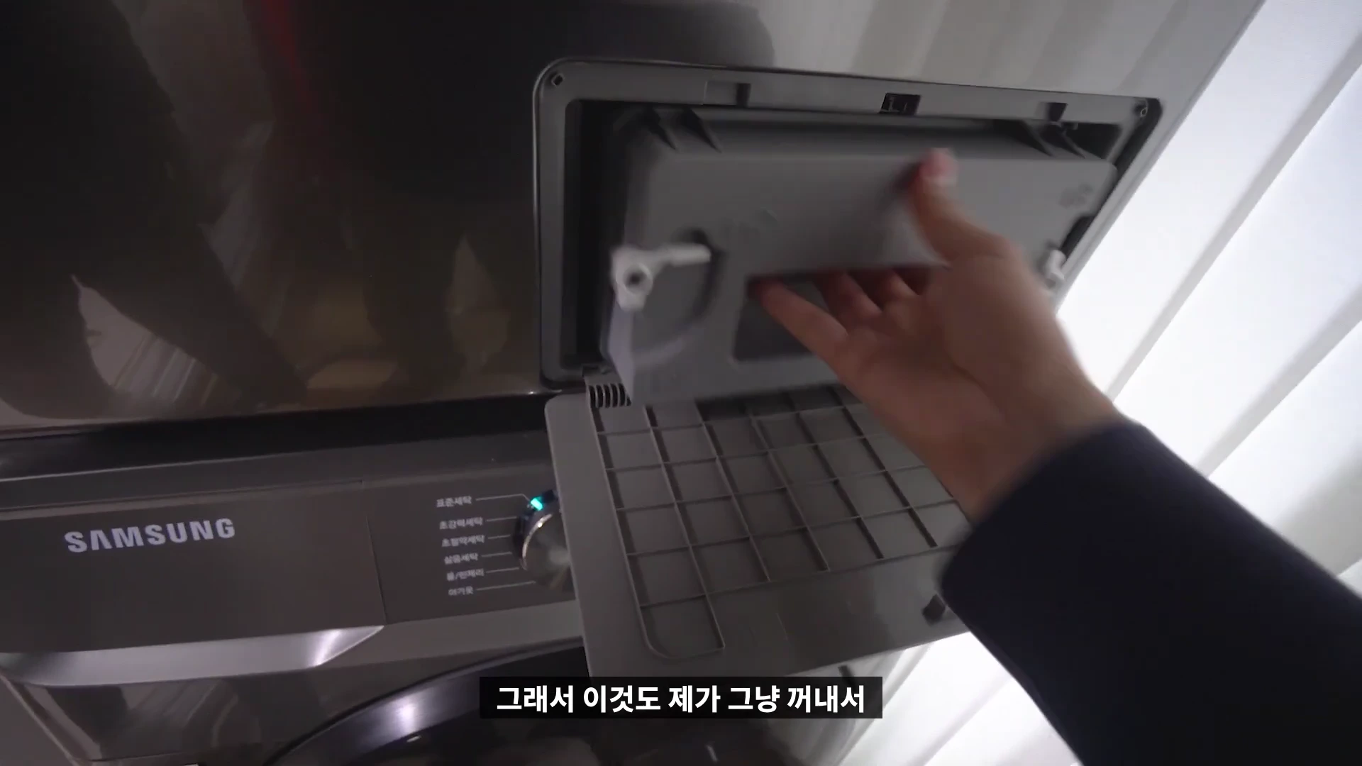 삼성 건조기 전면의 필터함을 손으로 열어 꺼내는 모습