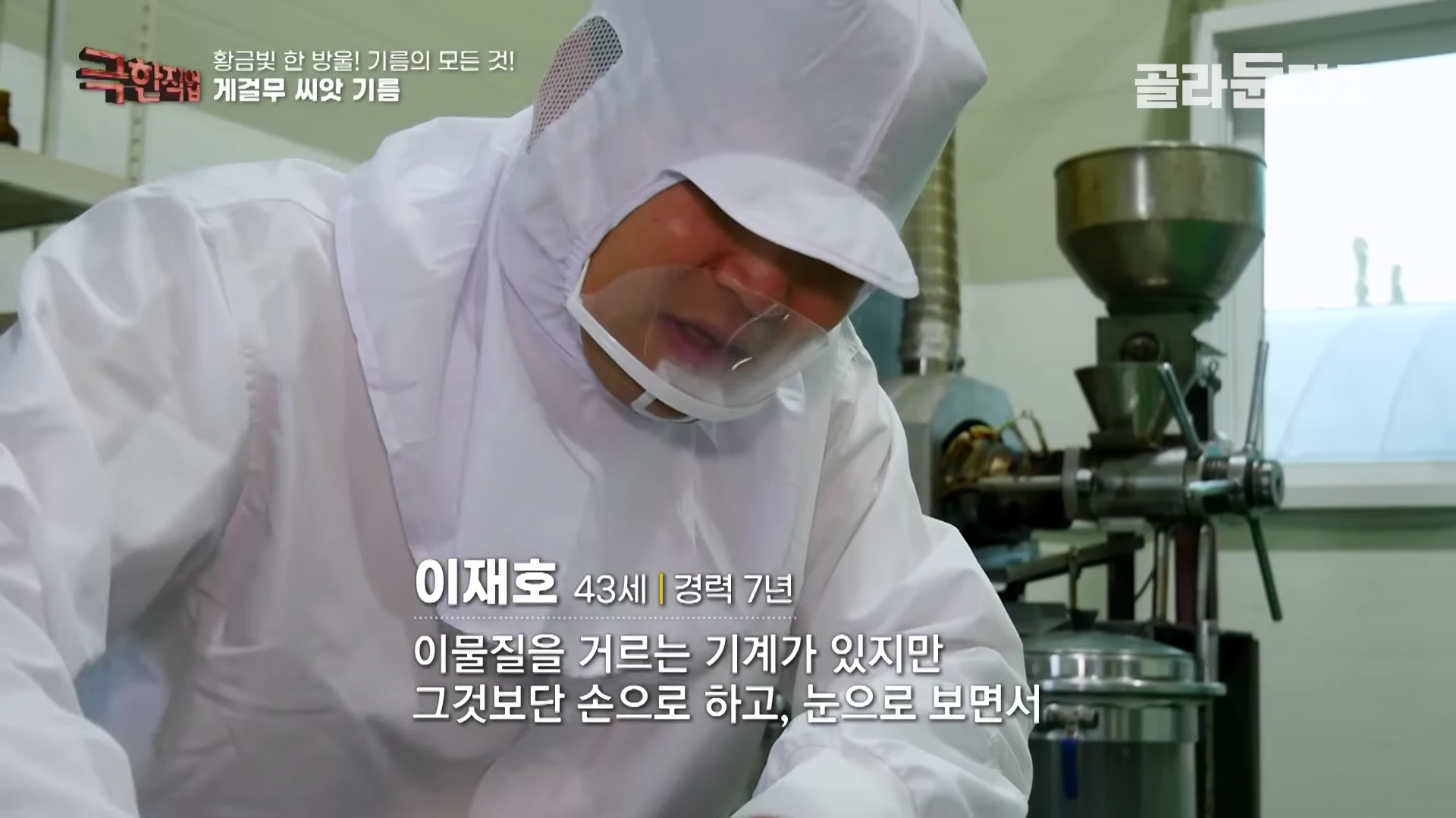 위생복을 입은 작업자가 진지한 표정으로 재료의 이물질을 직접 골라내고 있다.