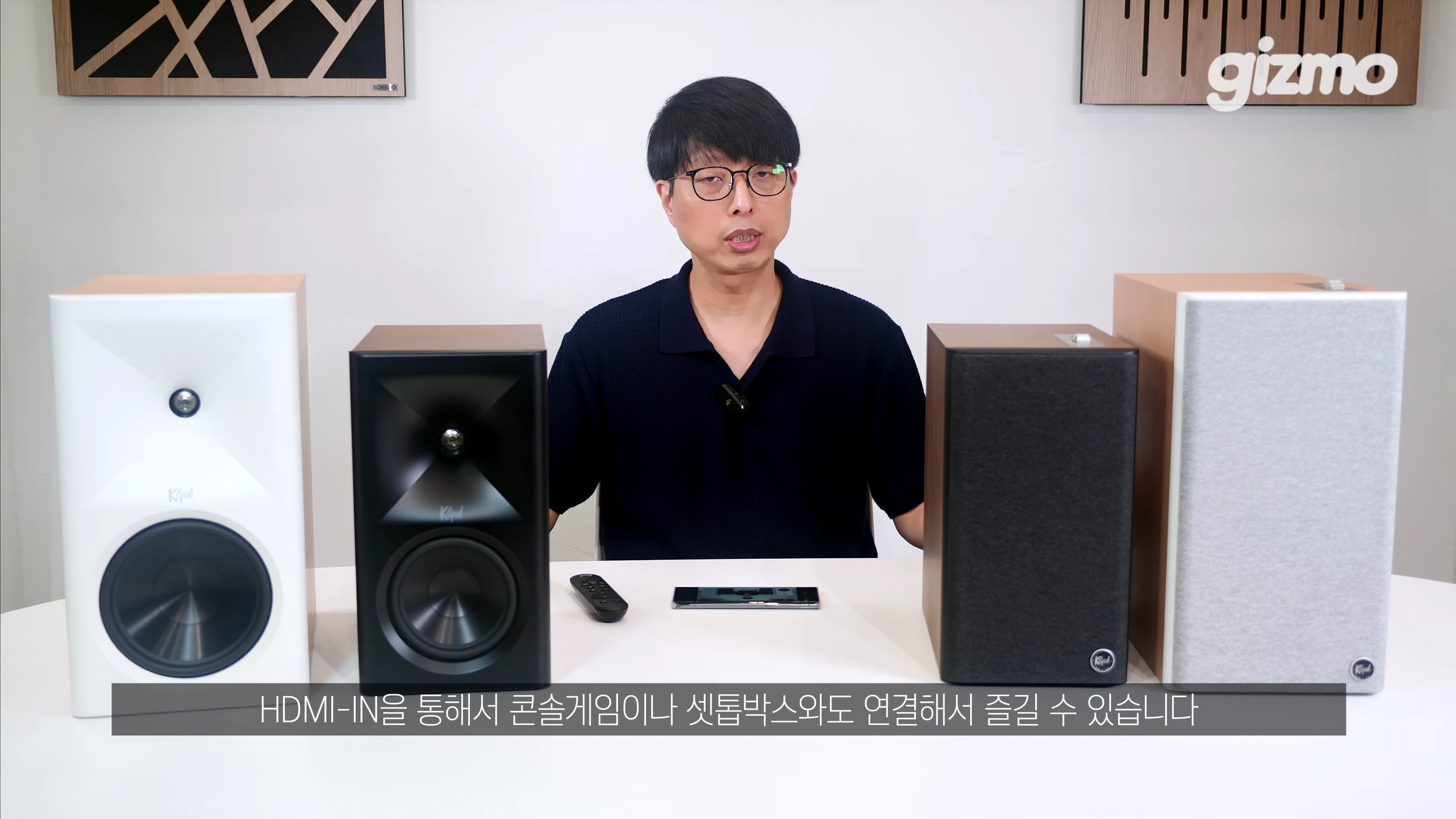 스튜디오에서 안경을 쓴 남성이 양옆에 클립쉬 스피커 2쌍을 두고 인터뷰 중인 모습