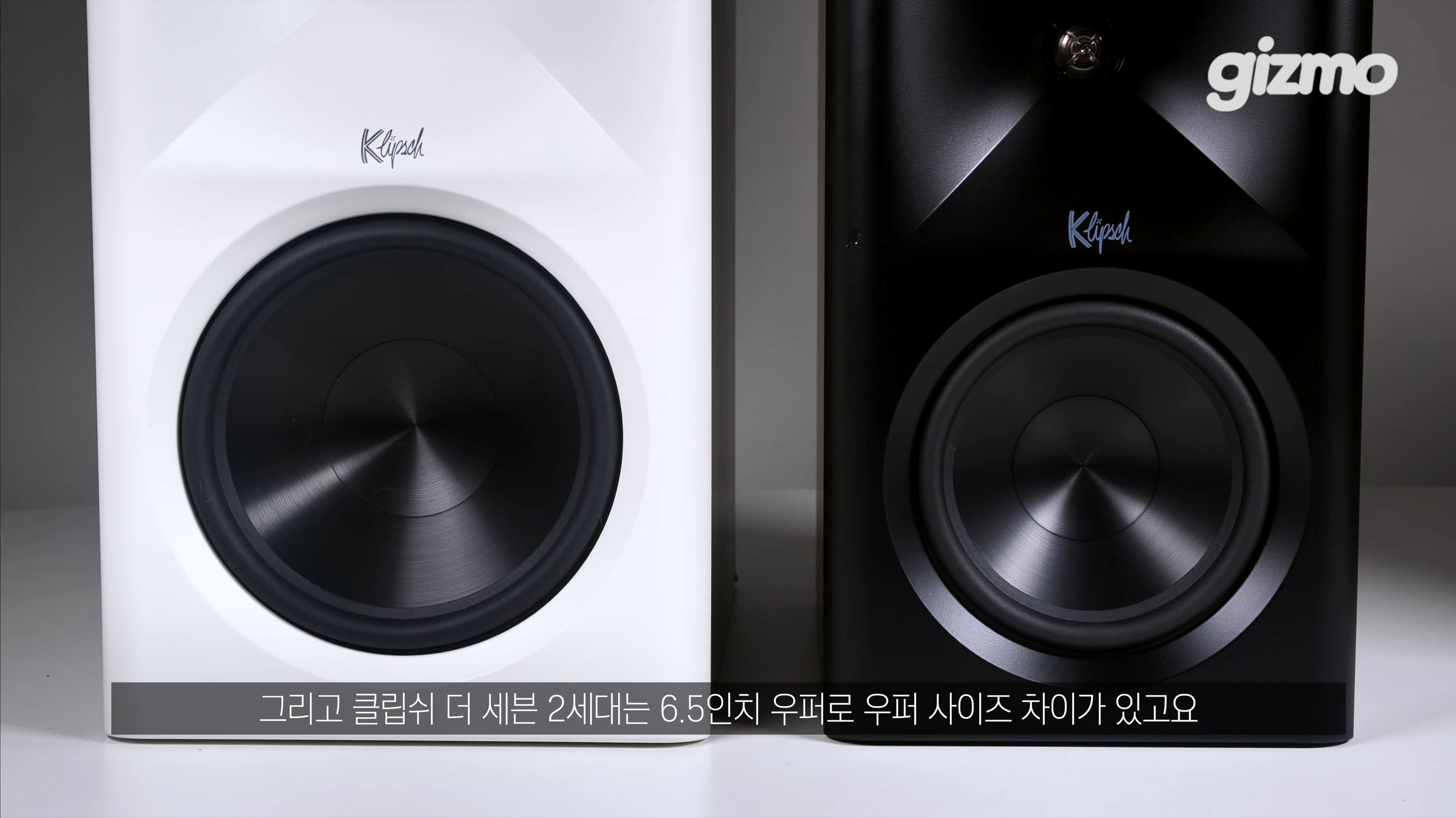 흰색과 검은색 클립쉬 액티브 스피커 두 대가 나란히 놓여 있는 모습