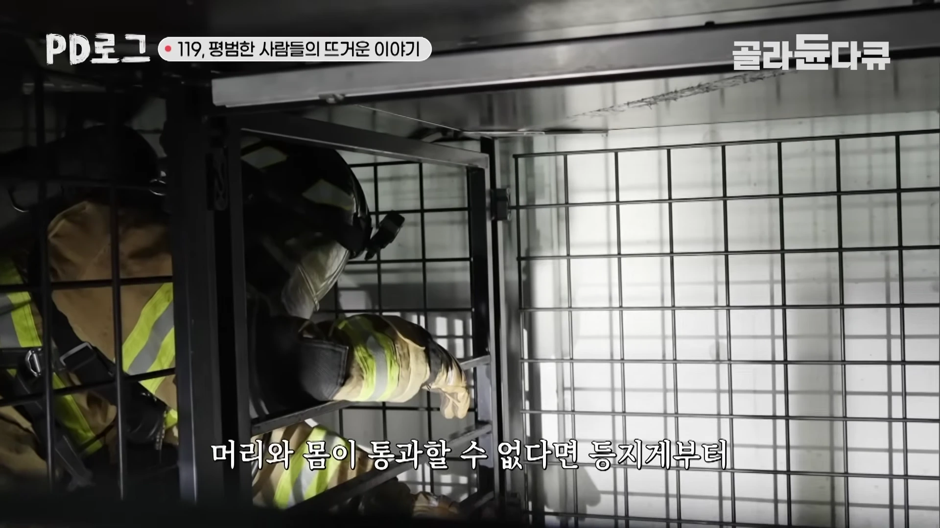 방화복과 헬멧을 착용한 소방관이 좁은 철창 미로 형태의 장애물 구간을 조심스럽게 통과하고 있는 모습