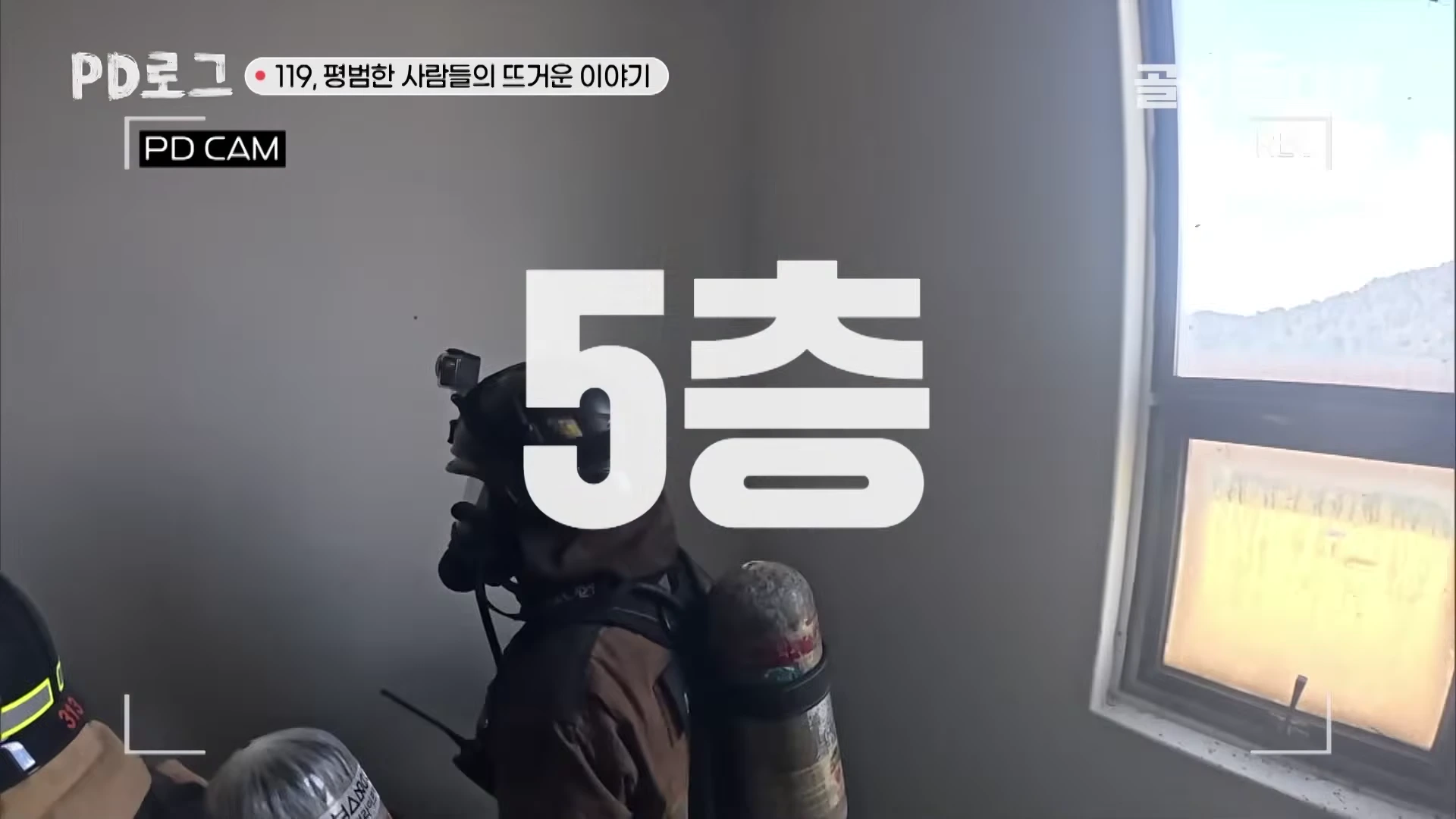 방화복과 공기통을 착용한 소방관들이 훈련탑 내부를 지나가는 모습