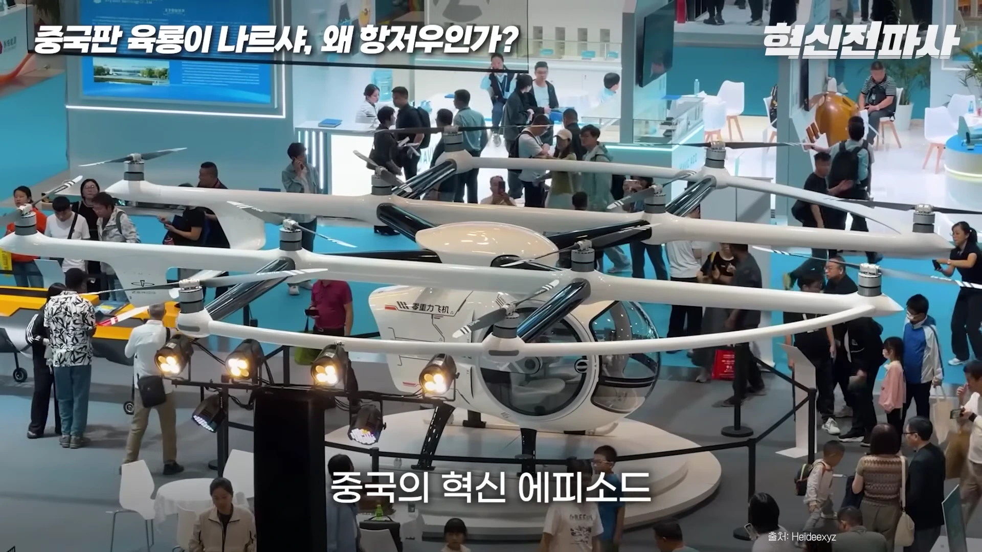 전시회장에 놓인 1인용 유인 드론 기체와 이를 둘러싼 관람객들