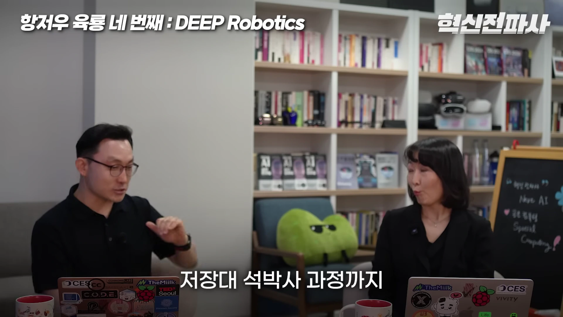 서재를 배경으로 마주 앉아 대화를 나누는 남녀 출연자들, 앞에는 스티커가 붙은 노트북이 놓여 있다.