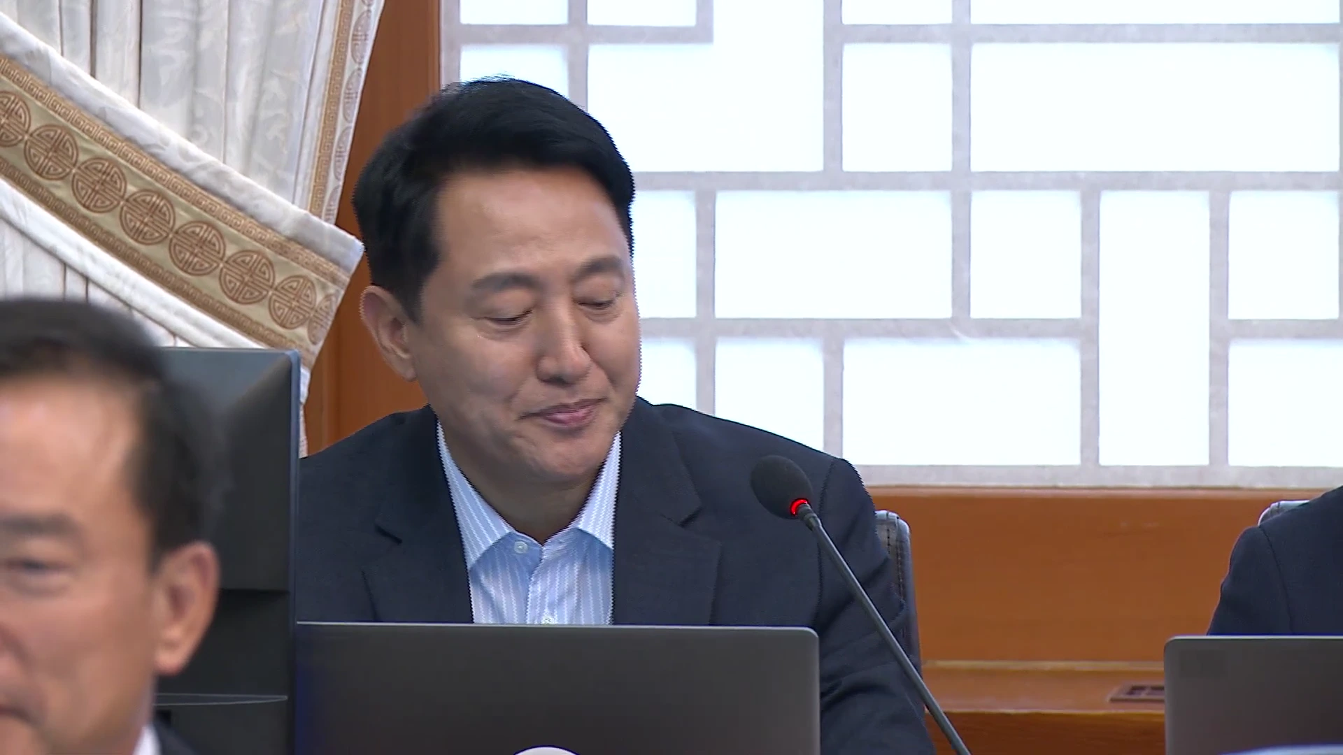 공식 회의 자리에 참석하여 노트북 앞에 앉아 발언을 준비하고 있는 남성의 모습