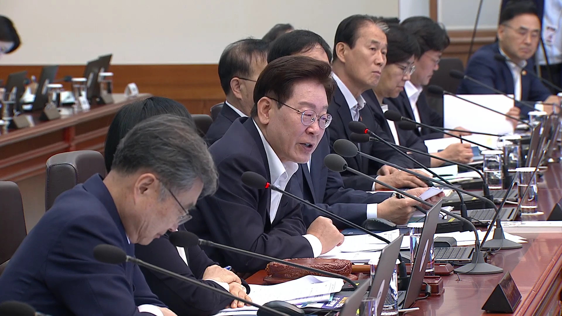 회의실 테이블에 앉아 발언 중인 중년 남성과 이를 경청하고 있는 국무위원들의 모습