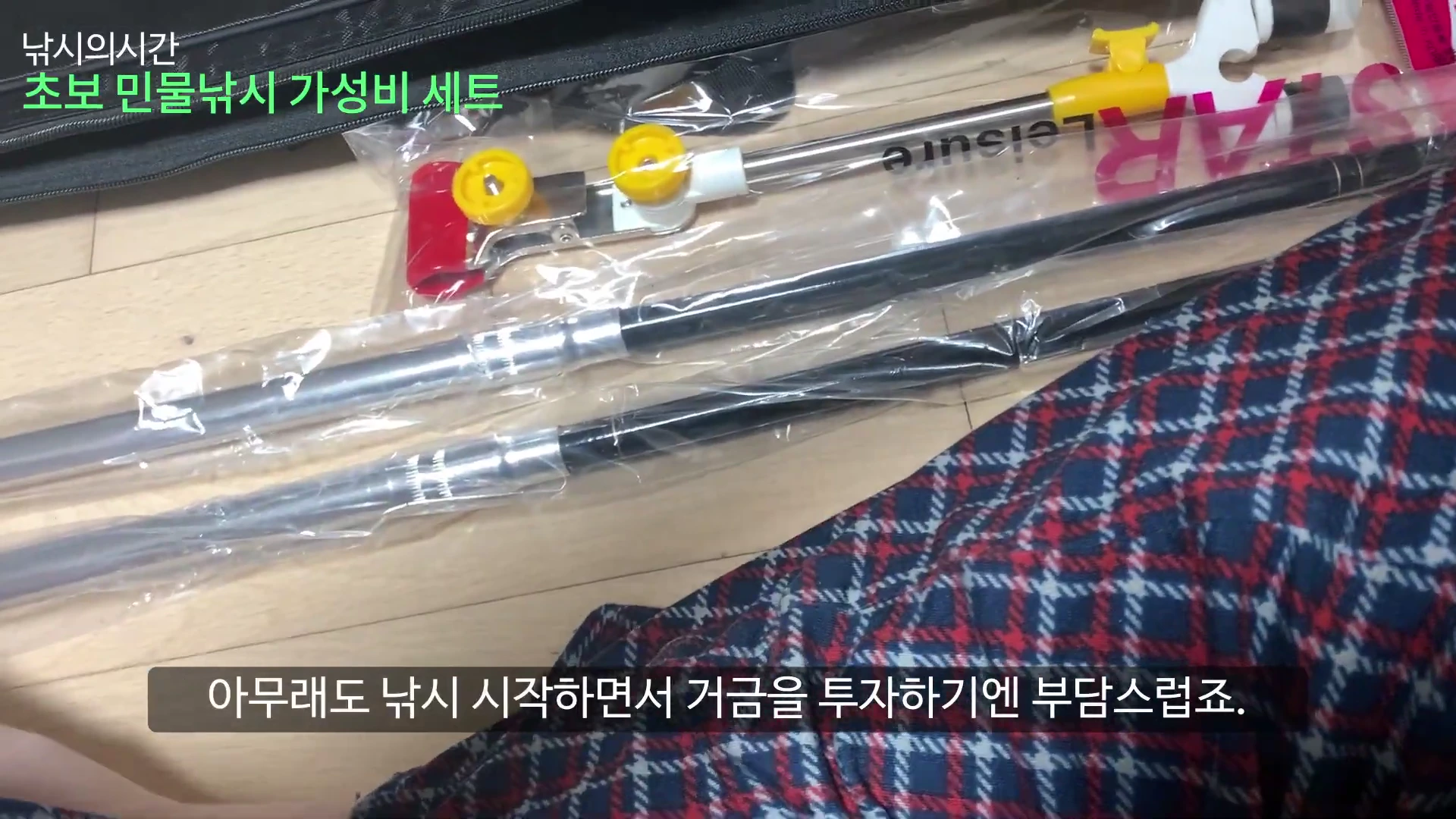 비닐에 포장된 낚싯대와 받침대 등 민물낚시 용품 세트가 바닥에 놓여 있고, 위쪽에는 녹색 텍스트로 '초보 민물낚시 가성비 세트'라는 자막이 보입니다.
