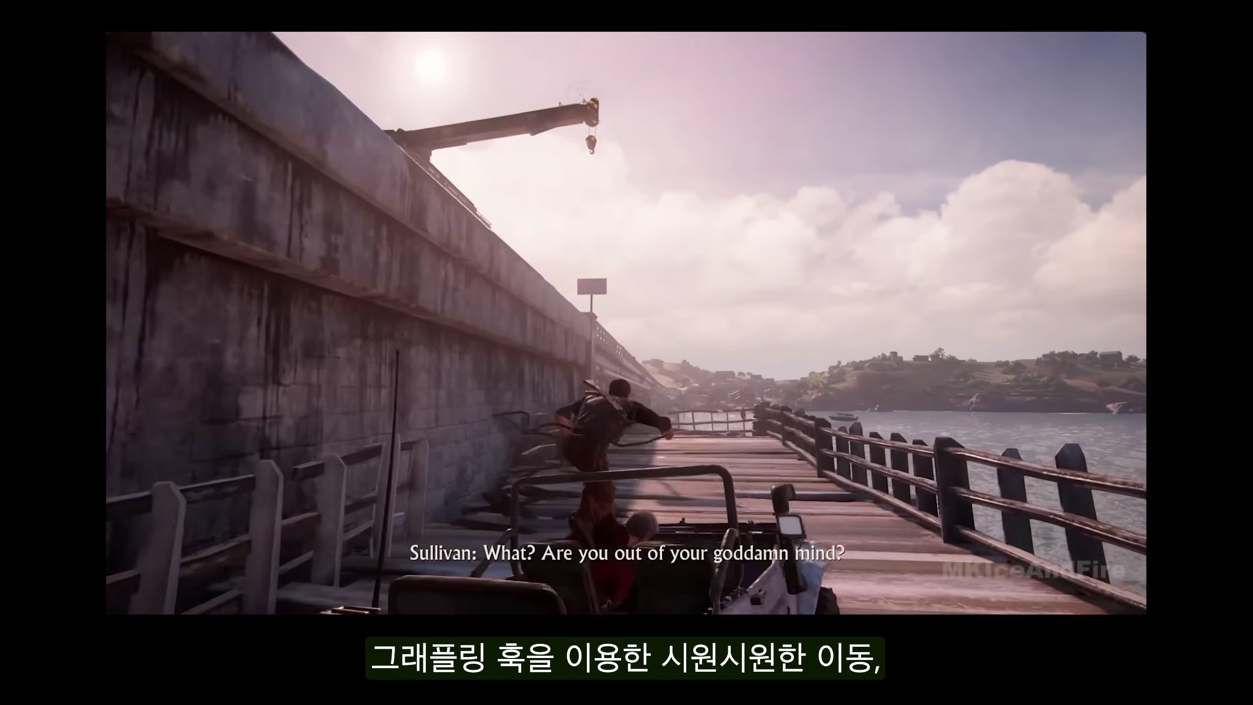 액션 어드벤처 게임의 한 장면으로 캐릭터가 달리는 차 위에서 그래플링 훅을 이용해 이동하는 모습이 광각으로 담겨 있고 하단에는 영문 자막이 있으며 그 아래 '그래플링 훅을 이용한 시원시원한 이동'이라는 한글 자막이 함께 표시되어 있습니다.