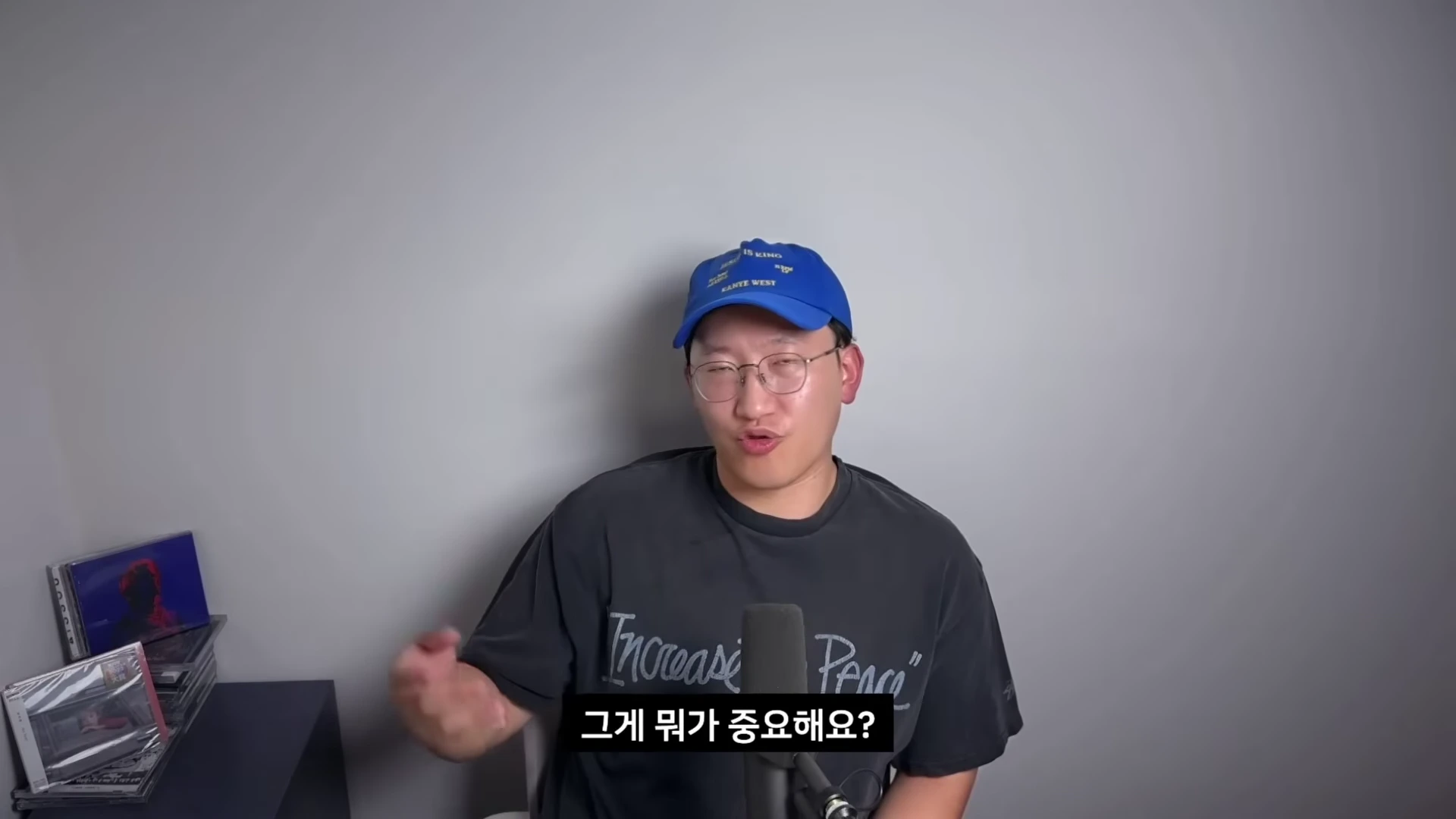 파란색 야구 모자를 쓴 남성이 마이크 앞에서 손짓하며 이야기하고 있으며, 화면 하단에는 '그게 뭐가 중요해요?'라는 자막이 표시되어 있습니다.