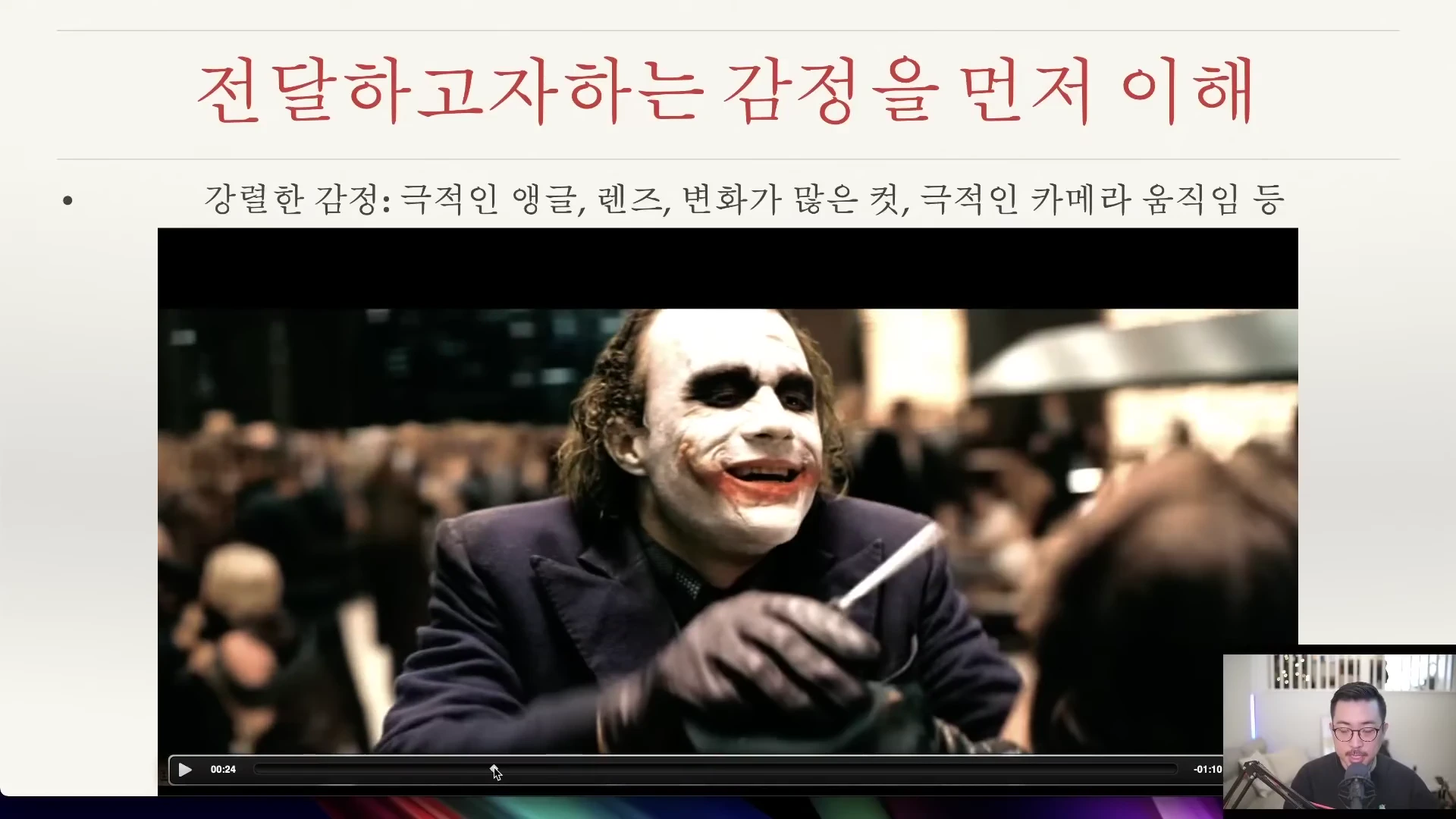 영화 속 조커 캐릭터가 나오는 영상 장면위에 강렬한 감정 연출 요소를 나열한 제목 슬라이드와 오른쪽 아래 작은 창에 발표자가 있는 화면 구성