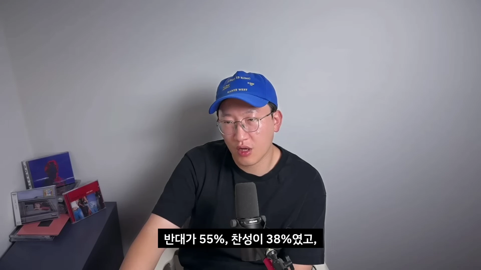 파란색 야구 모자를 쓴 남성이 마이크 앞에 앉아 이야기를 하고 있으며 화면 하단에는 자막이 떠 있습니다.