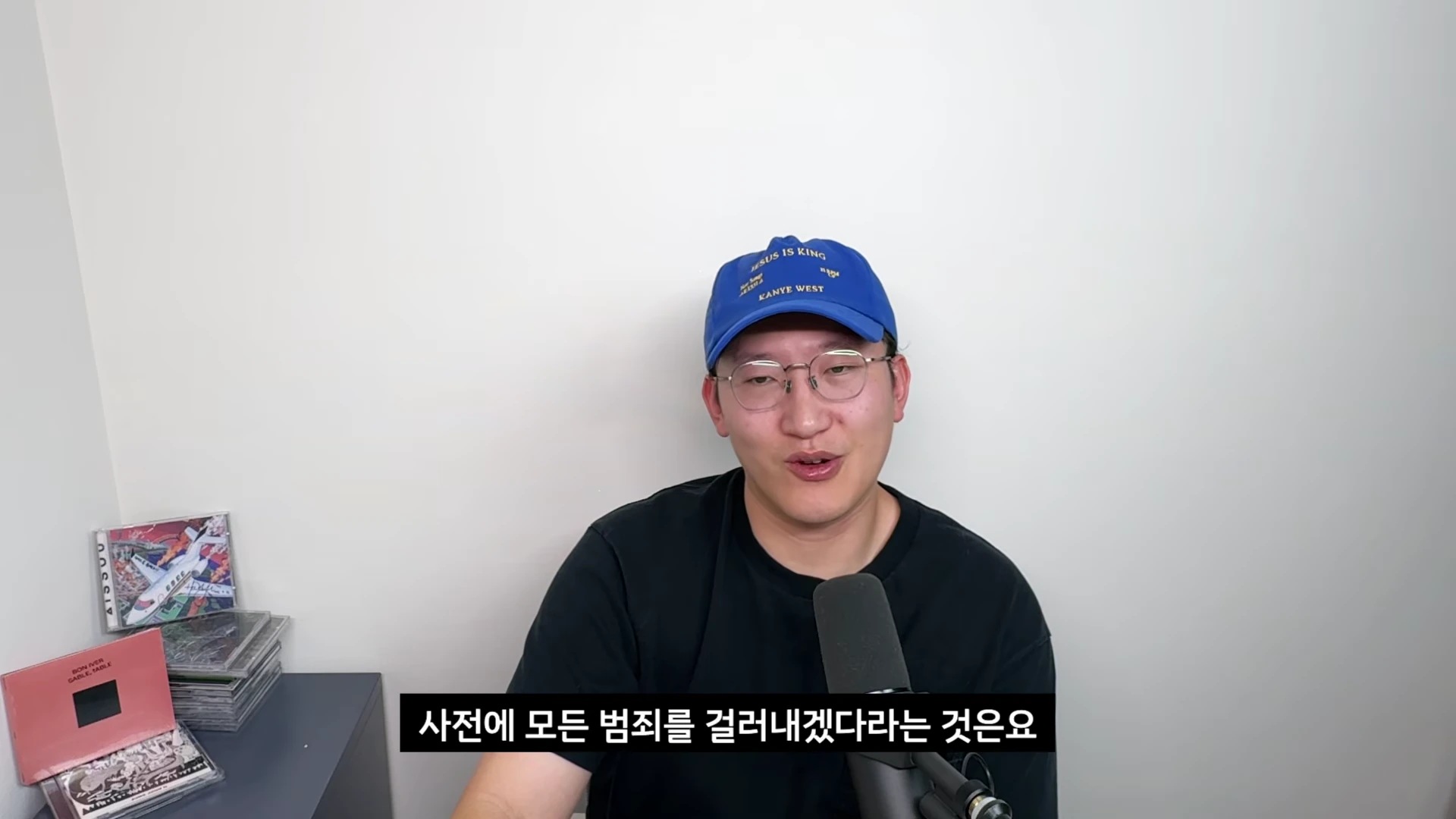파란색 야구 모자와 안경을 쓴 남성이 마이크 앞에 앉아 대화를 나누는 모습이 담긴 영상 캡처 화면