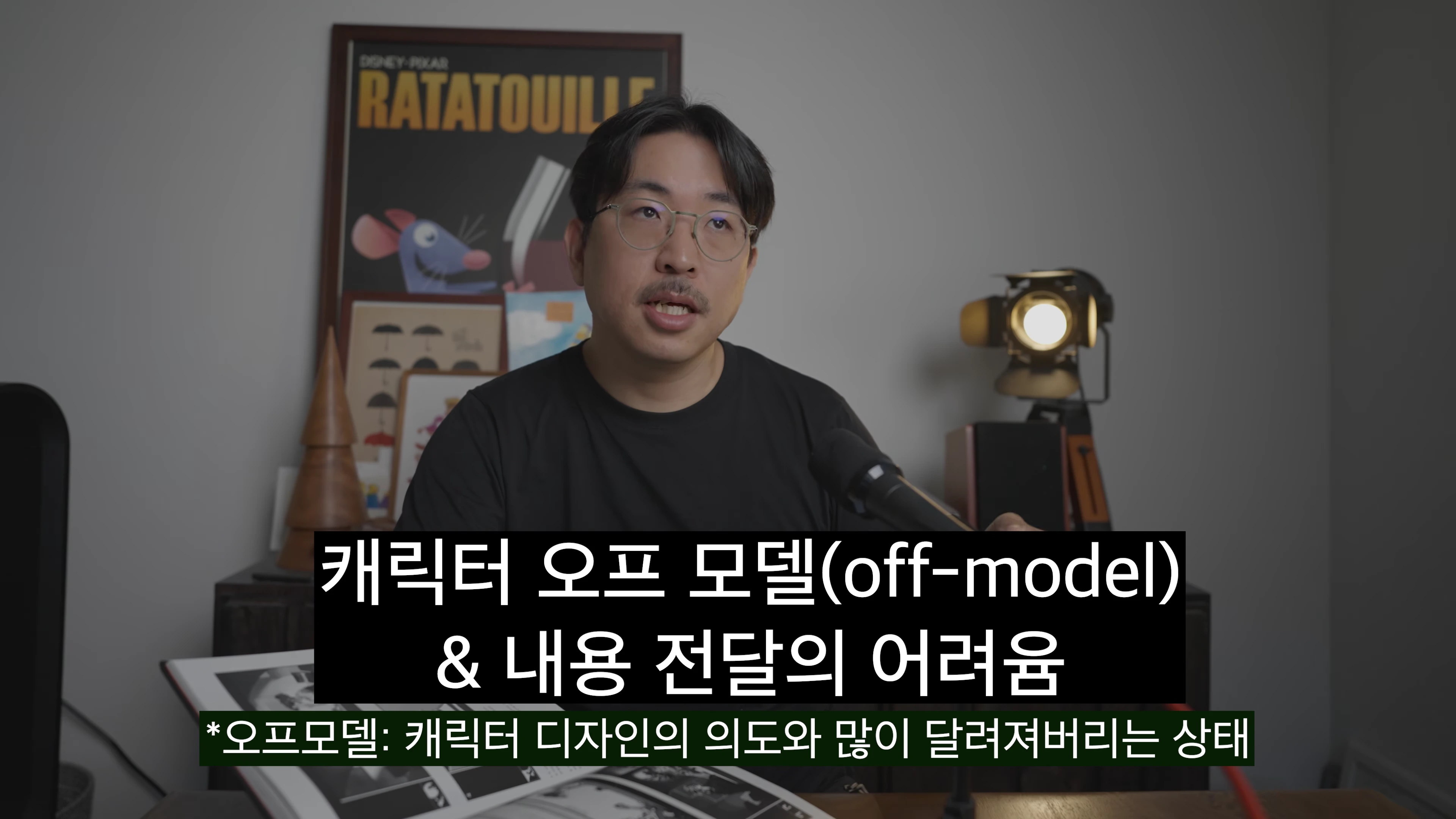 안경을 쓴 남성이 마이크 앞에서 대화하고 있으며 화면 하단에 검은색 배경의 한국어 자막이 삽입된 영상 캡처 화면입니다.