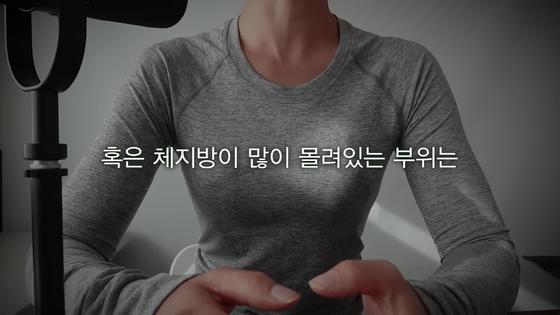 회색 긴팔 운동복을 입은 사람이 의자에 앉아 이야기를 나누고 있으며, 화면 중앙에는 한국어 자막이 표시되어 있습니다.