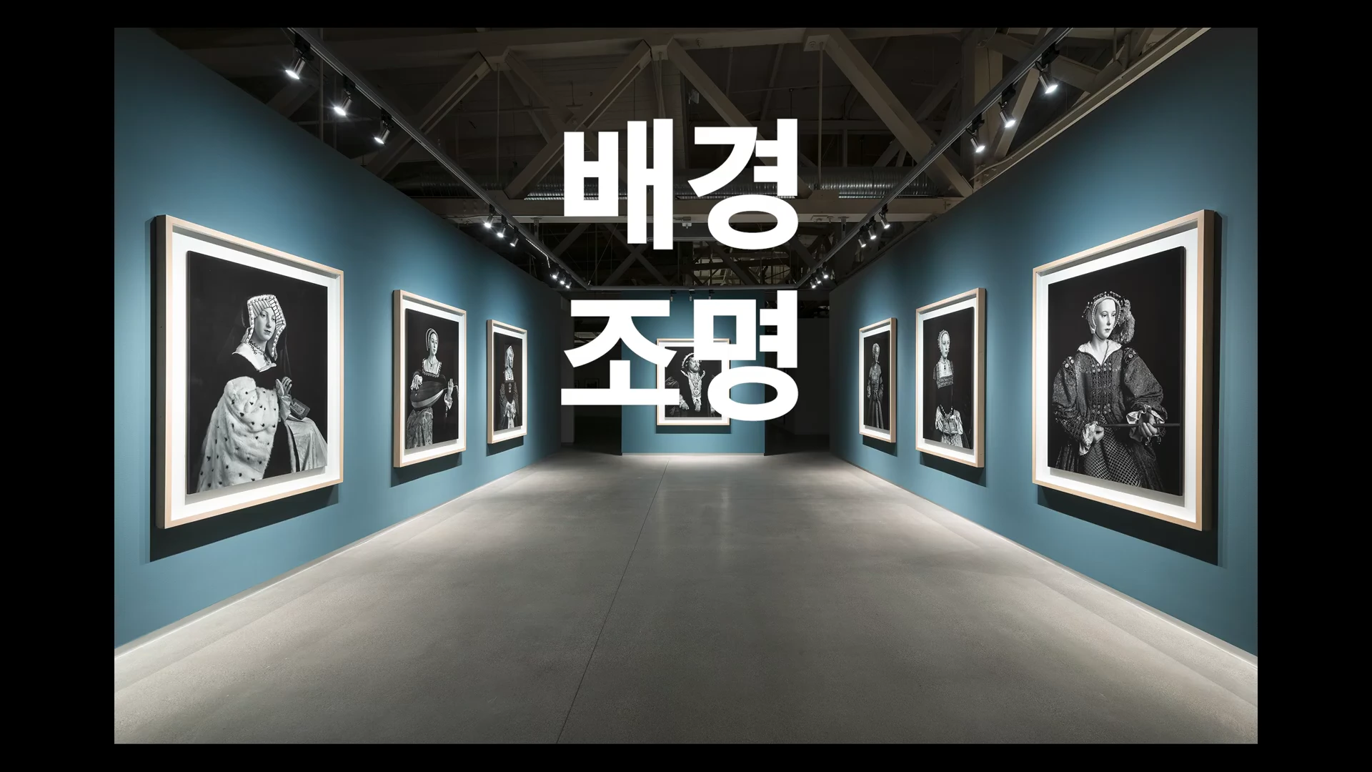미술관 내부 전시 공간을 촬영한 장면으로, 어두운 청록색 벽면에 흑백 인물화들이 일정한 간격으로 걸려 있고 중앙 상단에는 '배경', '조명'이라는 큰 흰색 한글 자막이 배치되어 있습니다.