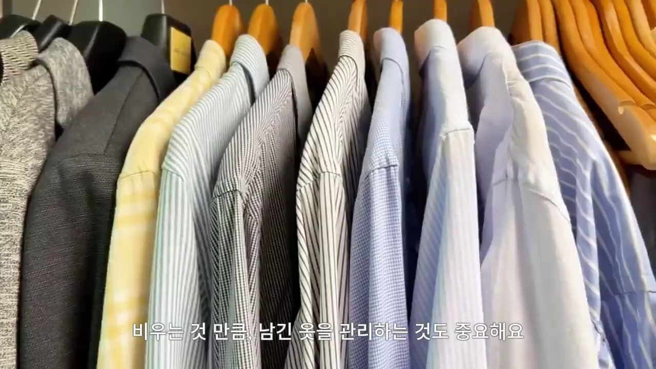 나무 옷걸이에 나란히 걸려 있는 다양한 색상과 패턴의 셔츠들