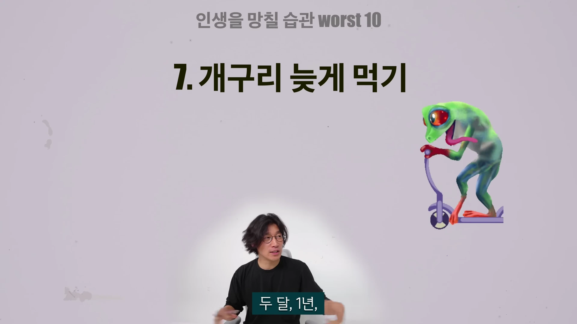 안경을 쓴 남성이 밝은 배경의 화면 앞에 앉아 이야기하고 있으며, 화면 상단에는 '인생을 망칠 습관 worst 10'이라는 제목과 함께 '7. 개구리 늦게 먹기'라는 글자가 크게 적혀 있고 옆에는 킥보드를 타는 개구리 캐릭터가 그려져 있습니다.