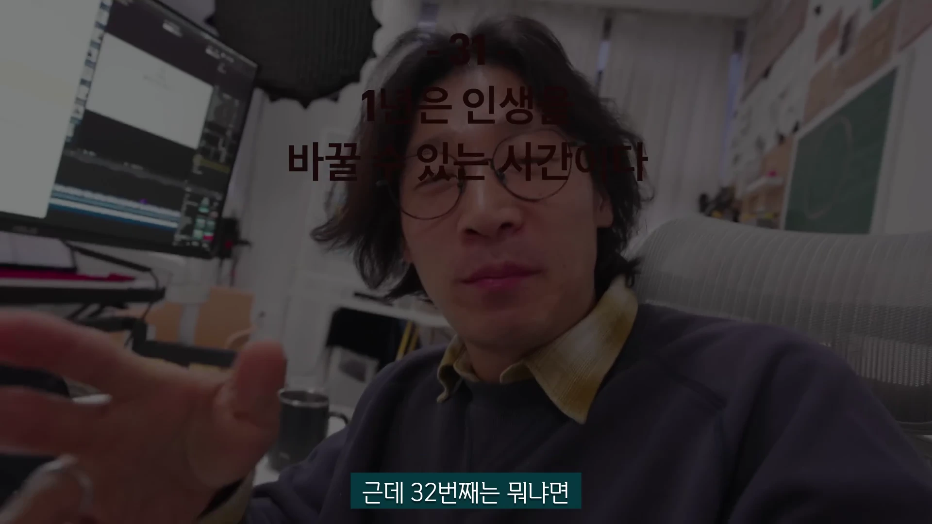 안경을 쓴 한 남성이 실내에서 카메라를 응시하며 손짓을 하고 있고, 화면 위에는 '1년은 인생을 바꿀 수 있는 시간이다'라는 자막이 입혀져 있습니다.