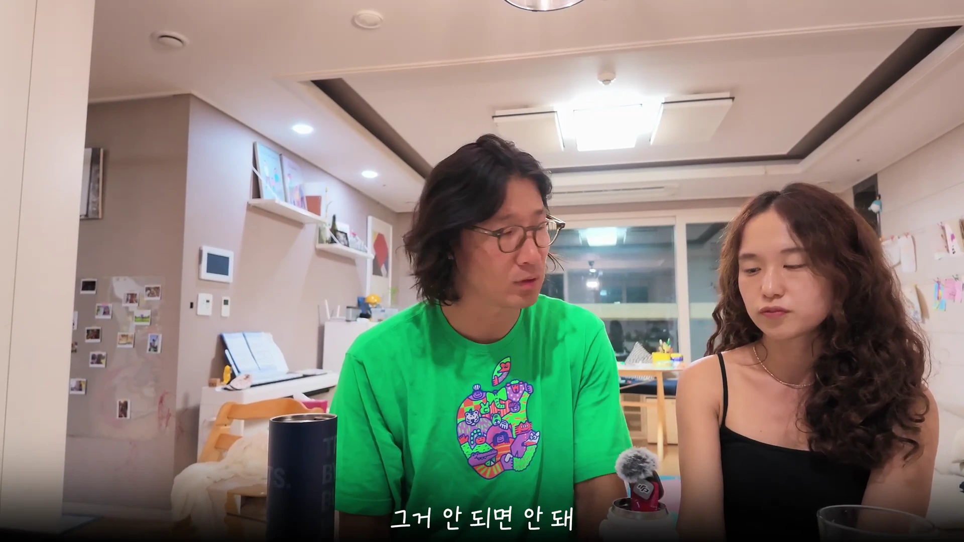 실내에서 나란히 앉아 대화를 나누고 있는 부부의 모습이다.