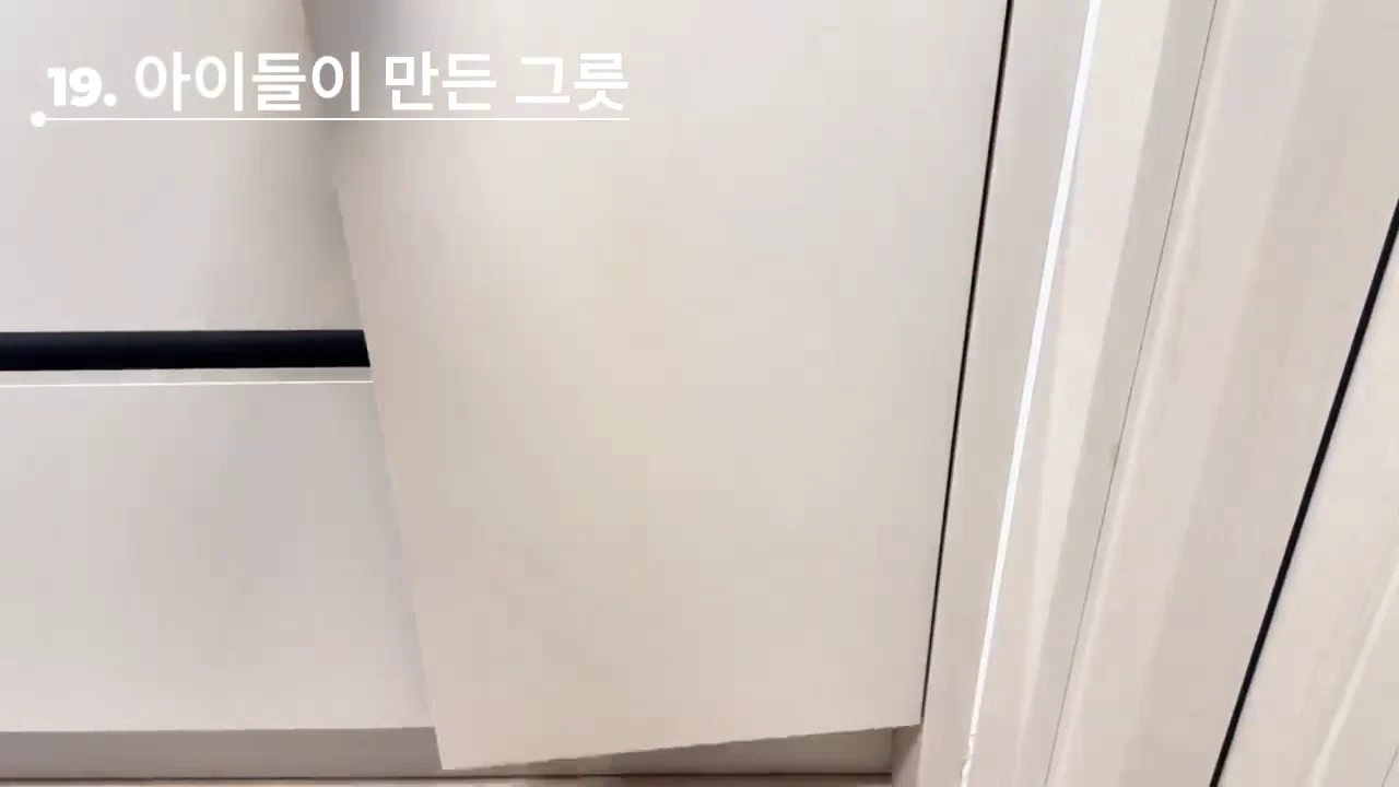 흰색 수납장 문이 열리는 모습과 함께 '19. 아이들이 만든 그릇'이라는 흰색 자막이 화면 상단에 표시되어 있다.