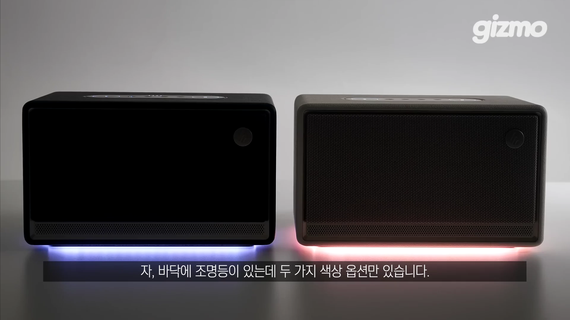 두 대의 직사각형 형태 스피커가 나란히 놓여 있으며, 스피커 하단에서 각각 푸른색과 붉은색의 은은한 조명이 나오고 있는 모습