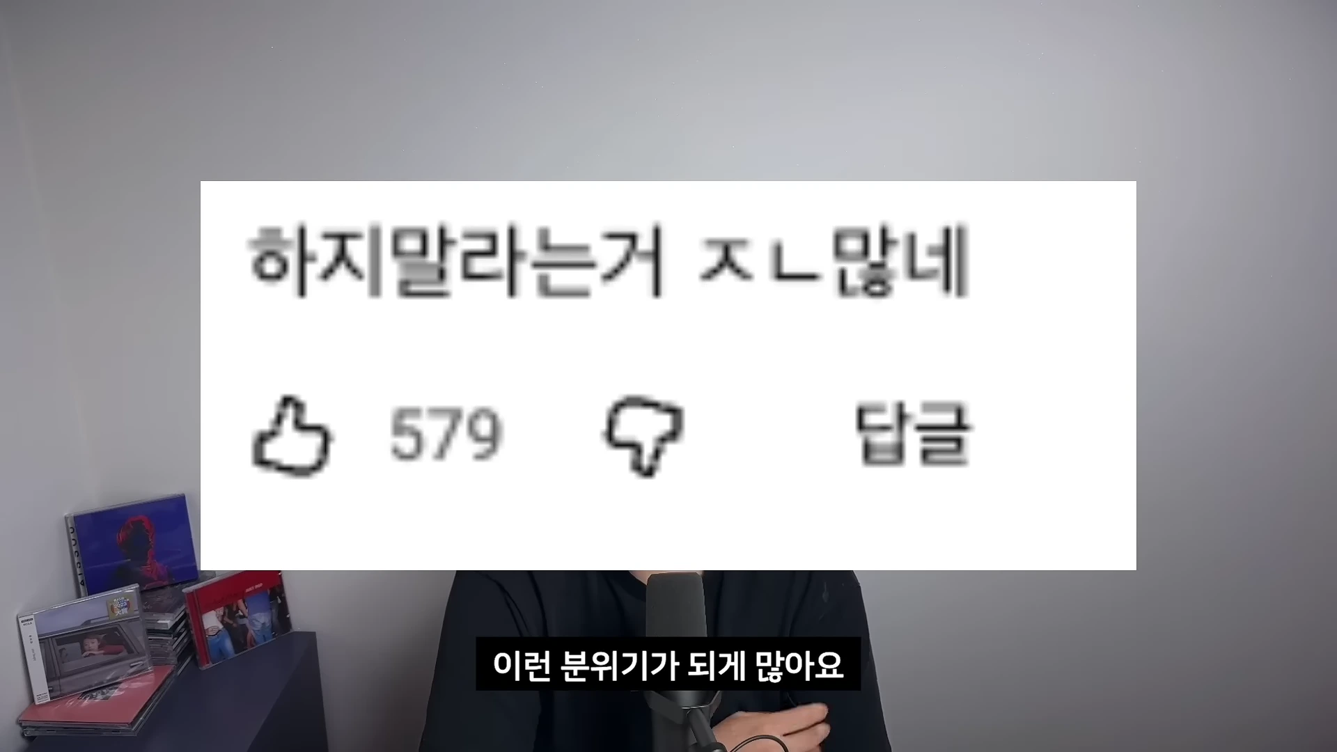 화면 중앙에 '하지말라는거 ㅈㄴ많네'라는 문구가 적힌 댓글 캡처 이미지가 있고, 그 아래에는 스피커를 마주한 인물이 앉아 있는 모습이 담겨 있습니다.