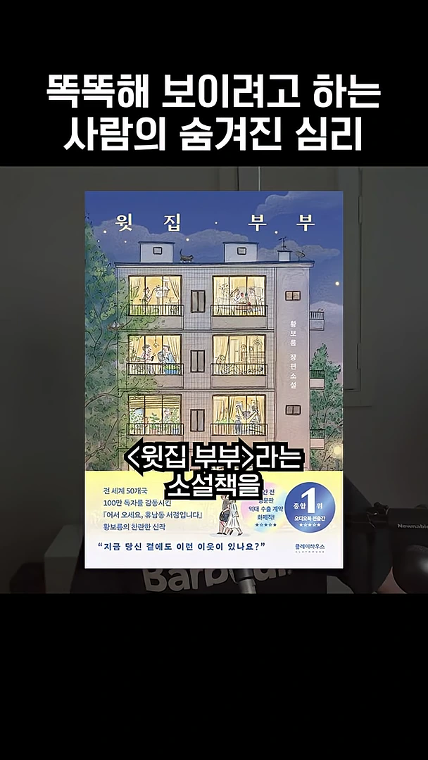 소설 '윗집 부부'의 표지 이미지와 그 위에 '똑똑해 보이려고 하는 사람의 숨겨진 심리'라는 자막이 겹쳐져 있는 영상 화면.