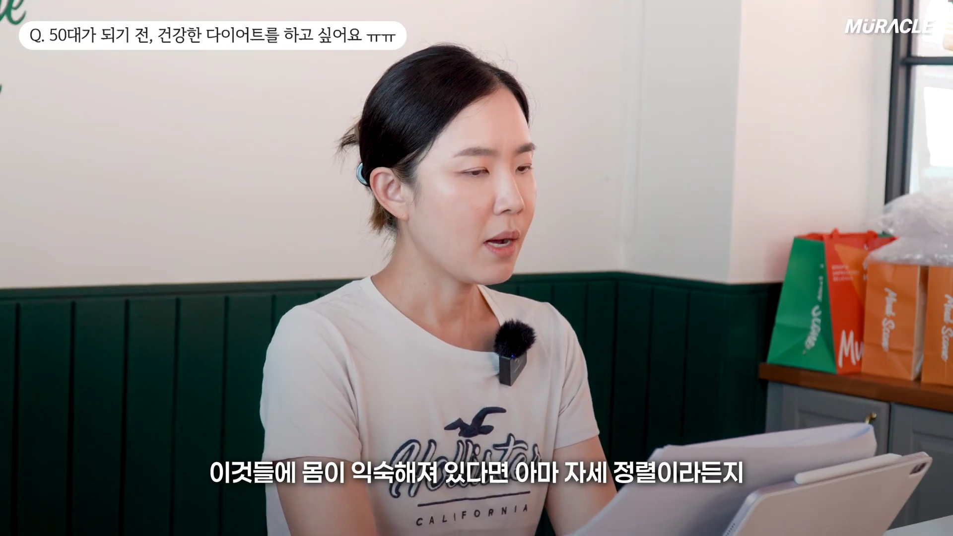 실내에서 베이지색 티셔츠를 입은 여성이 앉아서 이야기를 나누고 있으며, 화면 상단에는 상담 질문이 자막으로 표시되어 있습니다.