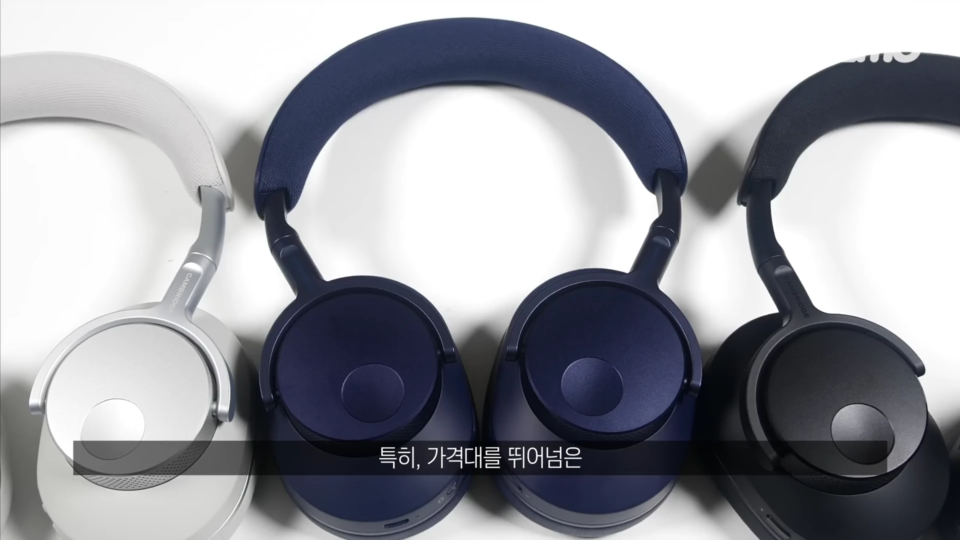 흰색, 남색, 검은색 무선 헤드폰 3대가 하얀 배경 위에 나란히 놓여 있는 모습