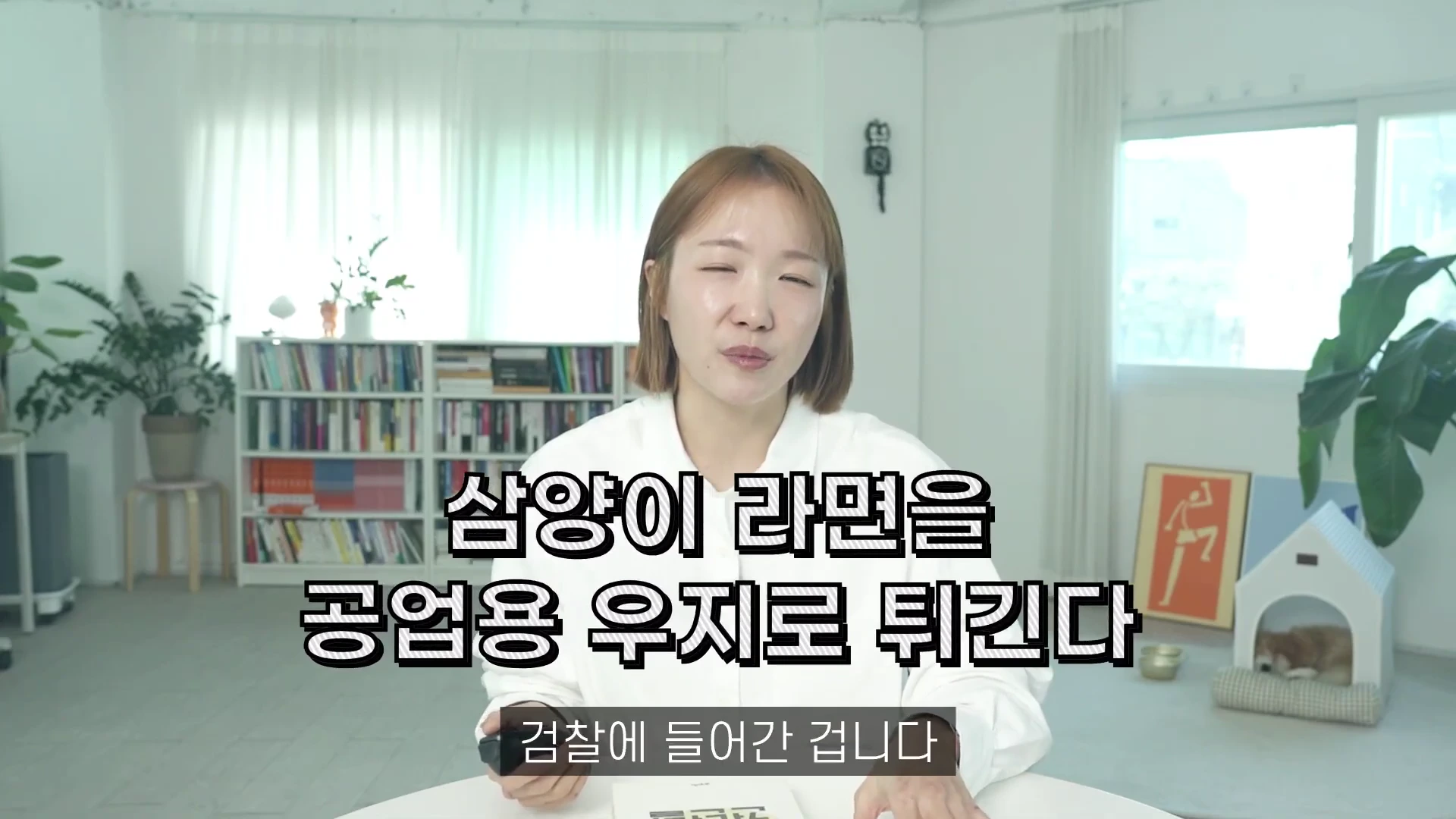 밝은 실내를 배경으로 흰 셔츠를 입은 단발머리 여성이 카메라를 향해 이야기를 하고 있으며, 화면 중앙에는 '삼양이 라면을 공업용 우지로 튀긴다'라는 검은색 테두리의 흰색 자막이 배치되어 있습니다.