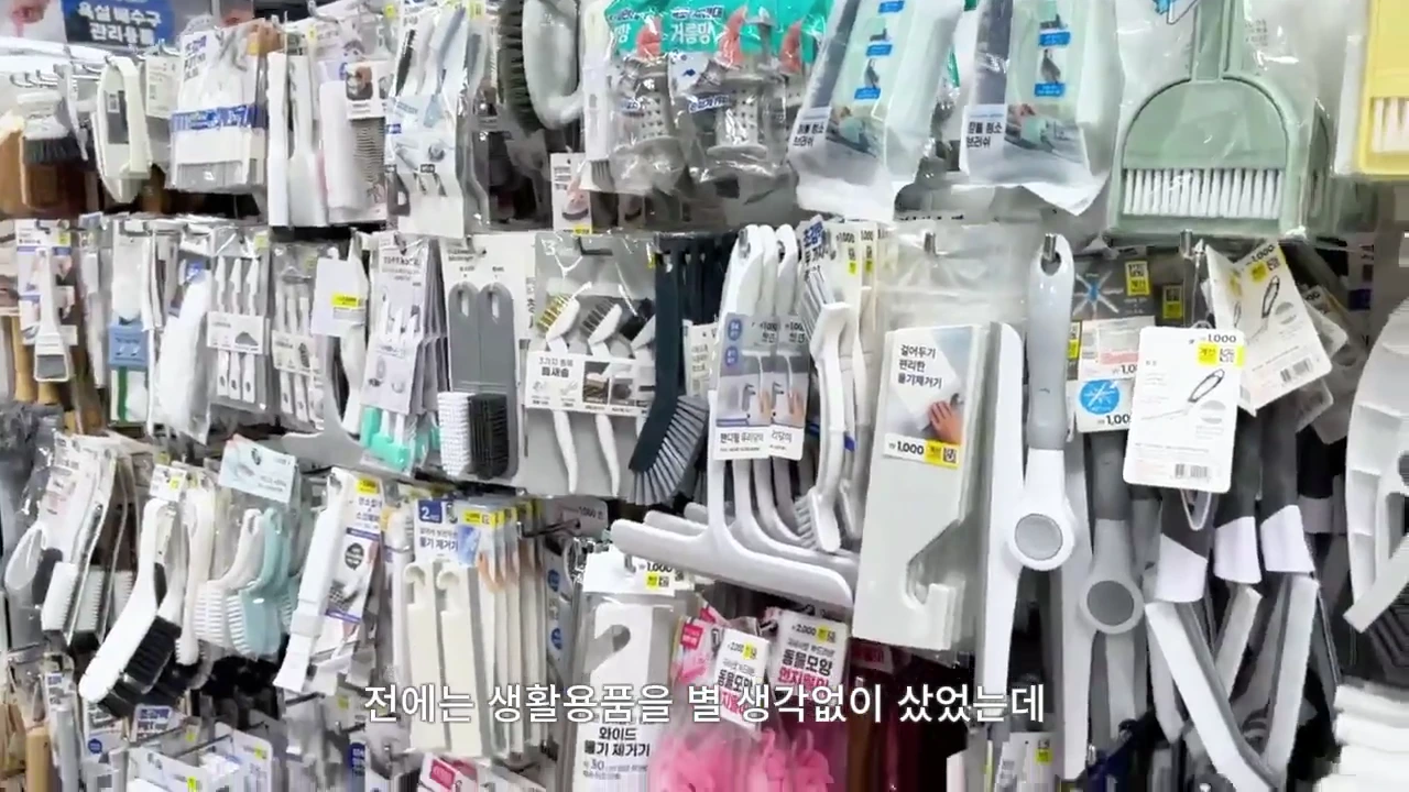 마트 진열대에 빽빽하게 걸려 있는 다양한 청소용 솔과 생활용품들