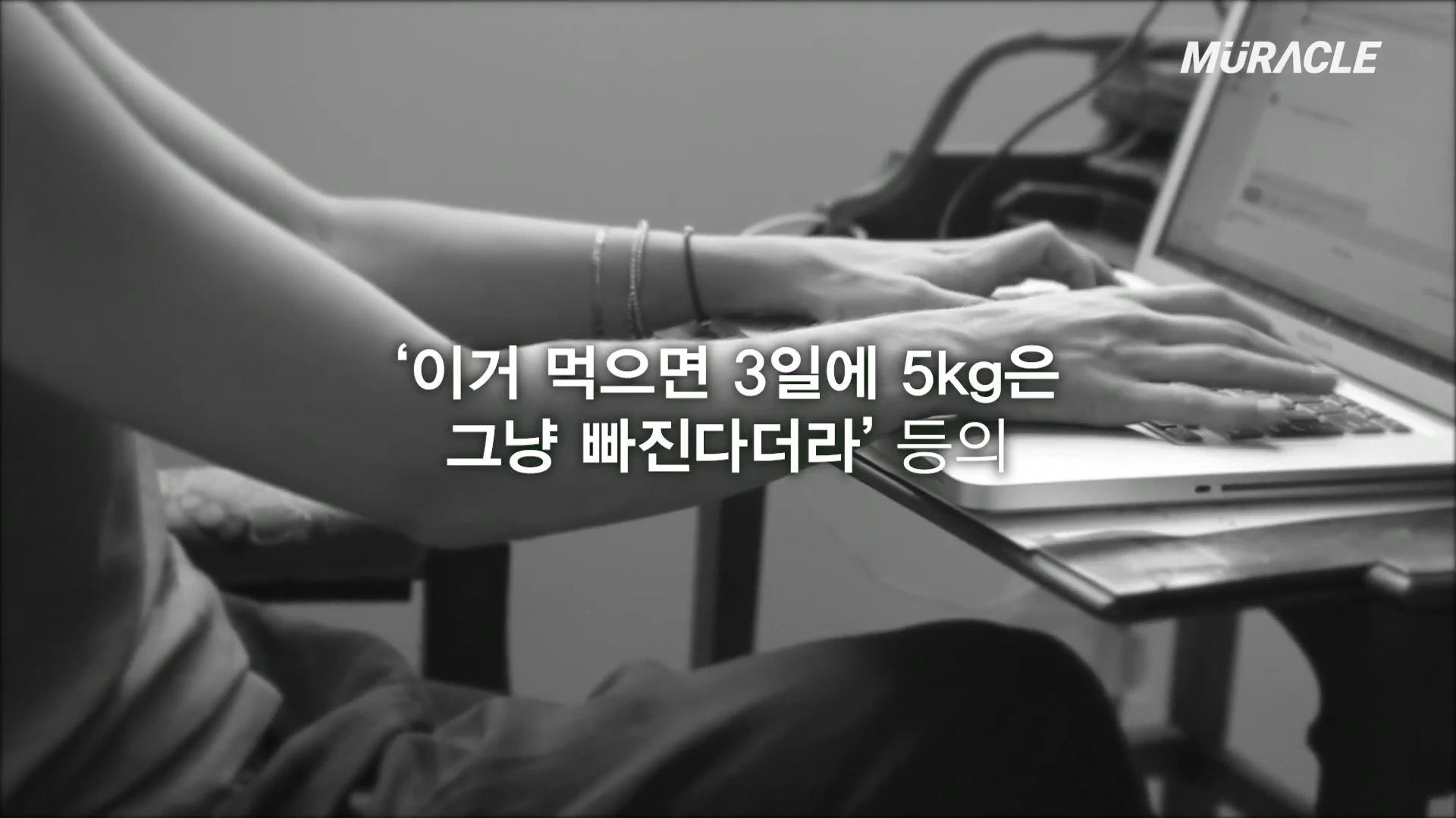 노트북 키보드를 타이핑하고 있는 사람의 손과 중앙에 '이거 먹으면 3일에 5kg은 그냥 빠진다더라'라는 자막이 흑백으로 표시된 영상 화면