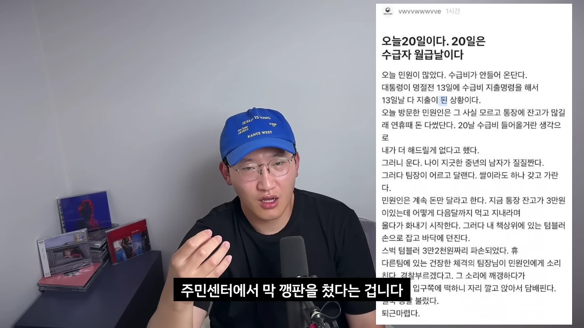 파란색 모자를 쓰고 안경을 쓴 남성이 마이크 앞에서 이야기하고 있으며, 화면 오른쪽에는 익명 커뮤니티의 민원 관련 게시글이 캡처되어 있습니다.