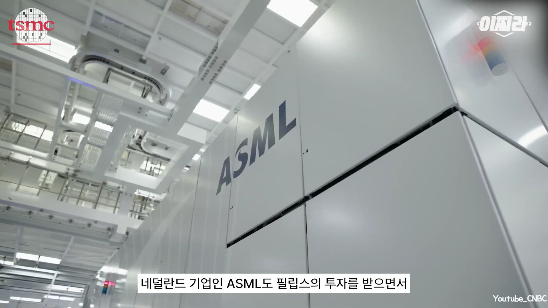 반도체 노광 장비 제조사 ASML의 로고가 새겨진 거대한 흰색 장비가 공장 내부에 설치되어 있는 모습