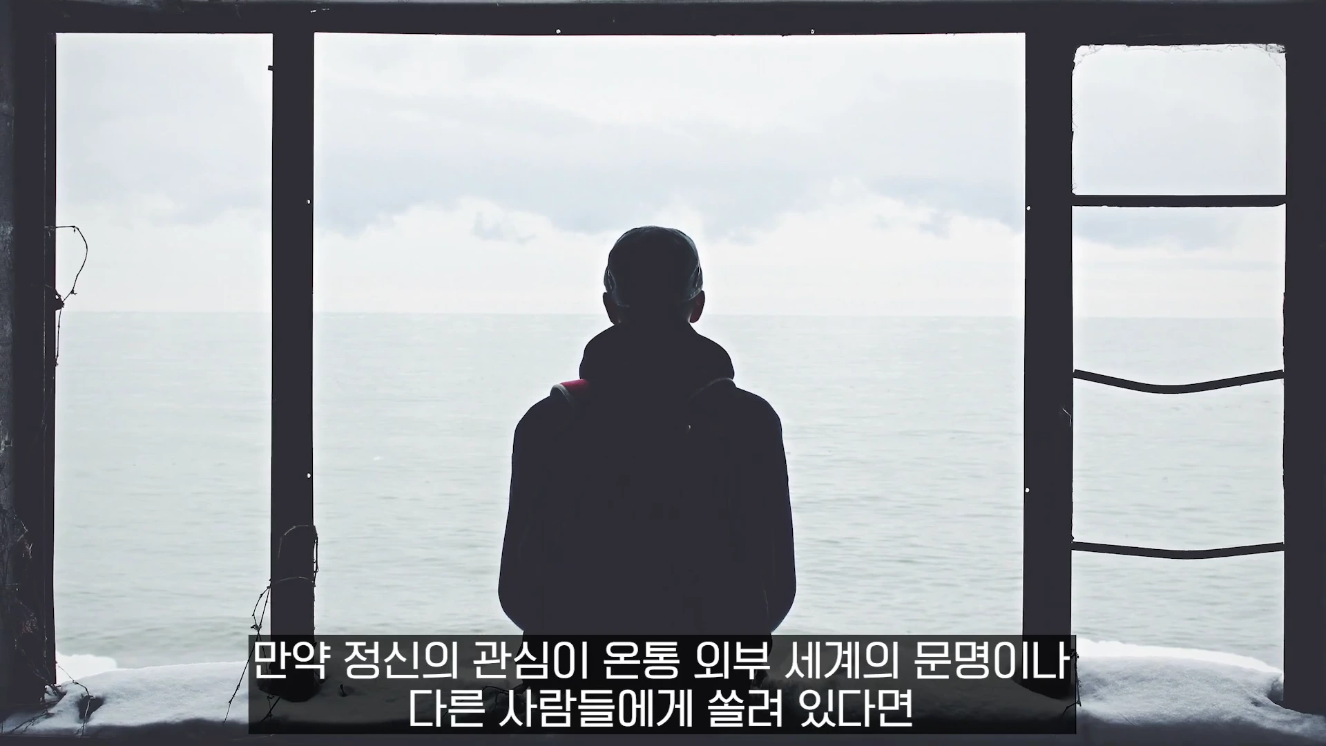 창문 너머로 보이는 바다를 향해 뒷모습을 보이며 앉아 있는 한 사람의 실루엣이 담긴 화면 하단에 한국어 자막이 표시되어 있습니다.