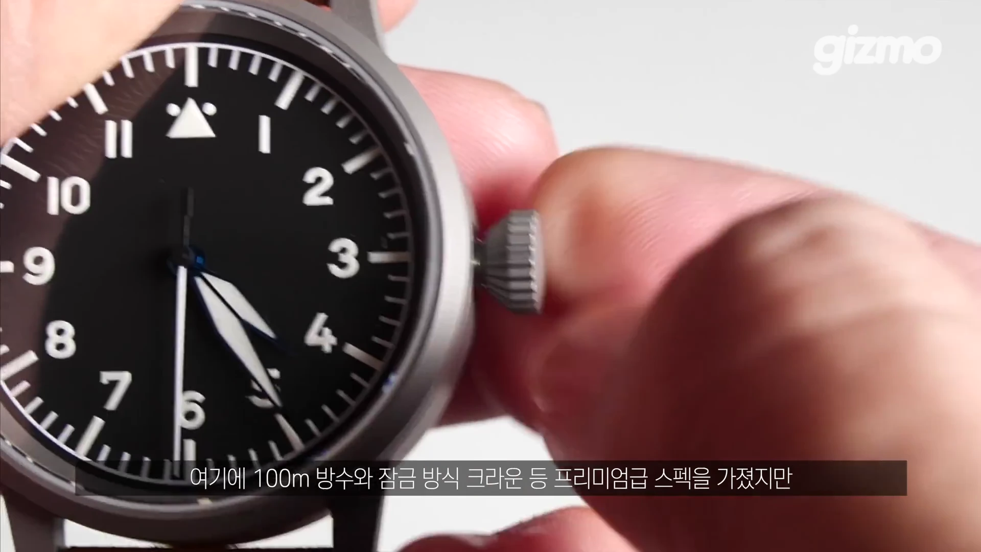 손으로 시계의 크라운을 돌려 조절하고 있는 모습이 담긴 클로즈업 화면