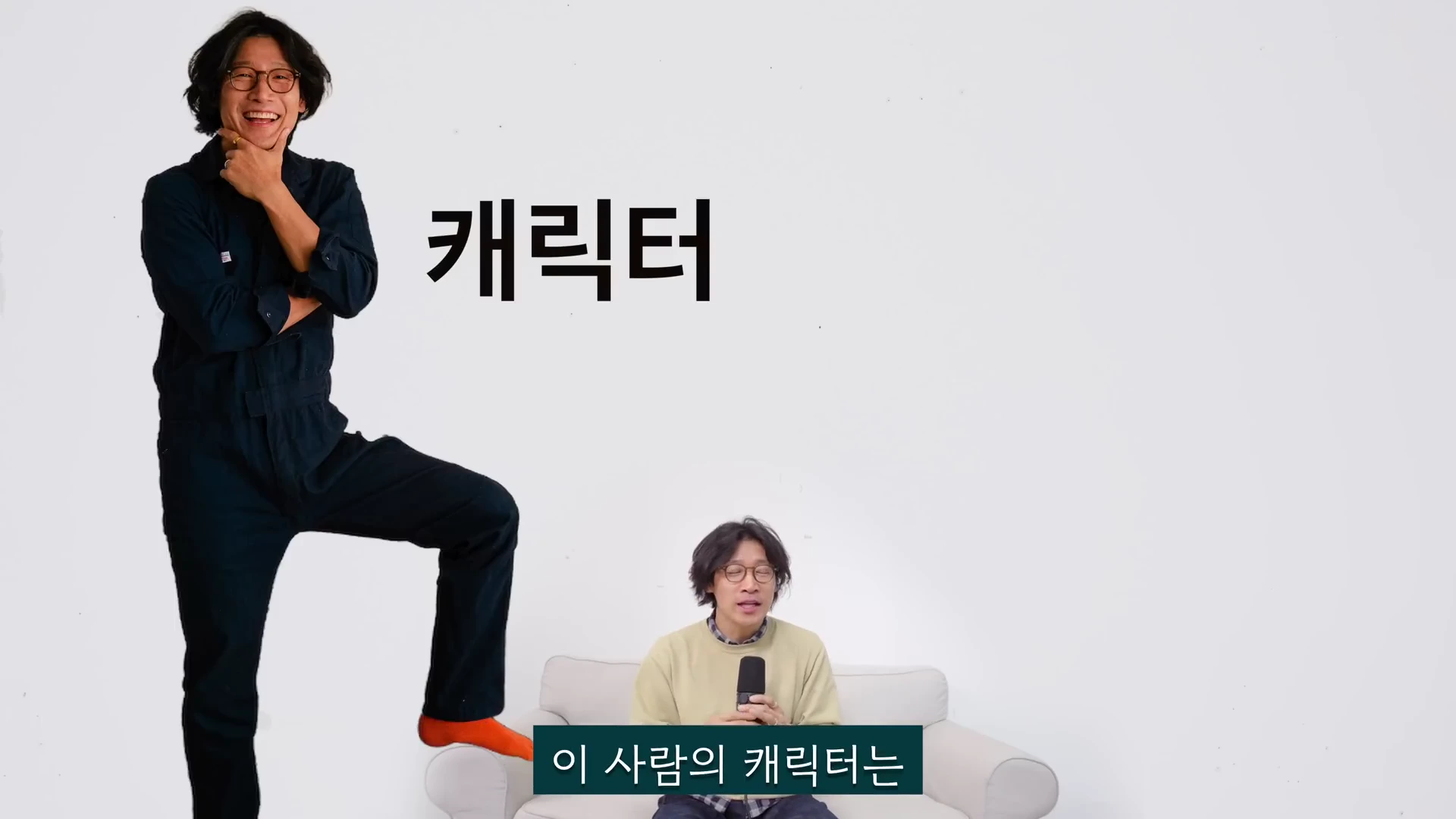 흰 배경 앞에 한 남자가 서 있고 그 앞에 같은 남자가 소파에 앉아 마이크를 들고 있는 모습. 서 있는 남자의 오른쪽에는 '캐릭터'라는 큰 글씨가 있고 하단에는 '이 사람의 캐릭터는'이라는 자막이 있음.