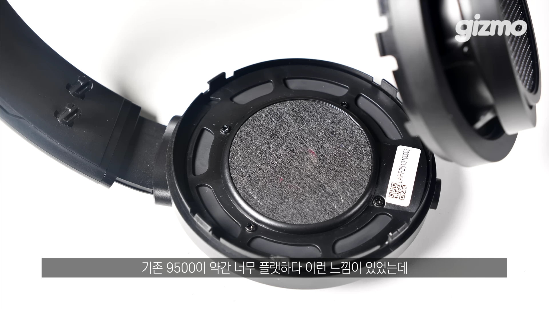 헤드폰의 이어패드가 분리되어 내부의 원형 드라이버 유닛이 드러난 모습이 클로즈업되어 있다.