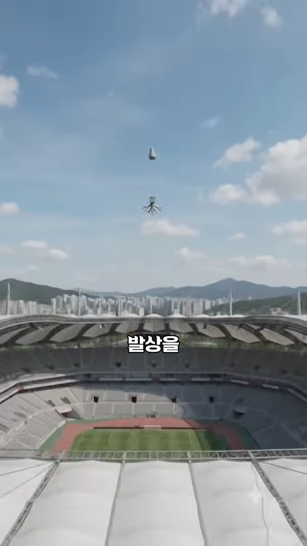서울월드컵경기장의 전경을 배경으로, 공중에 떠 있는 추 모양의 그래픽 아래 '발상을'이라는 글자가 적힌 영상 화면