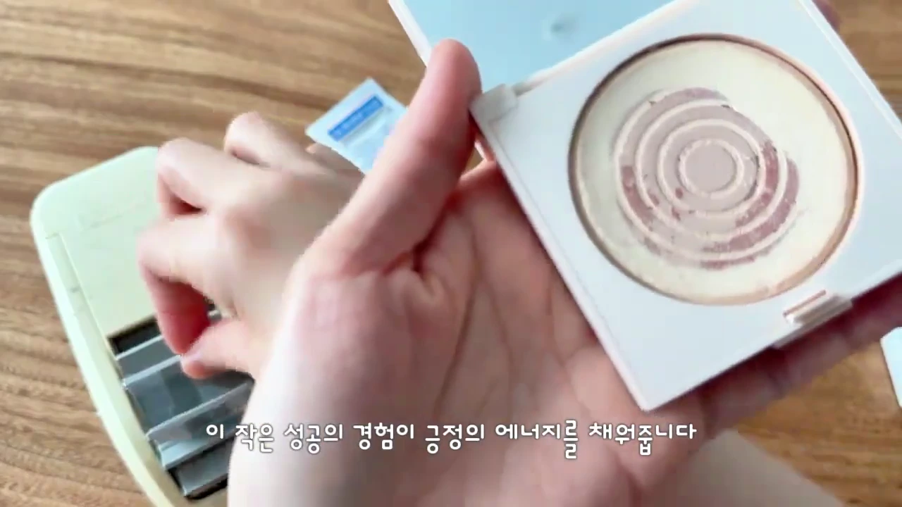 두 손으로 바닥이 거의 다 드러난 원형 팩트 케이스를 들어 보이고 있는 모습이다.