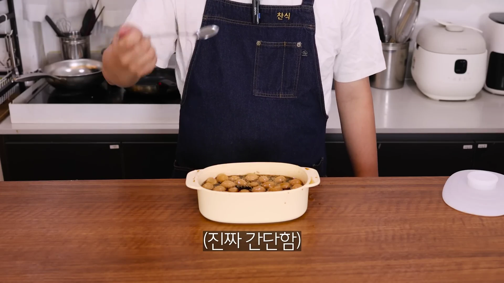 앞치마를 입은 요리사가 조리대에 놓인 그릇에 메추리알 장조림을 담고 있으며 화면 하단에 '진짜 간단함'이라는 자막이 표시되어 있다.