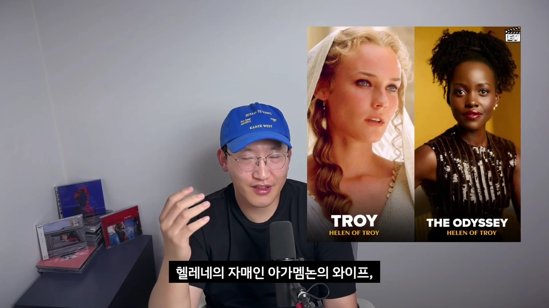파란색 야구 모자를 쓴 남성이 마이크 앞에 앉아 있고, 화면 오른쪽에는 영화 <트로이>의 헬레네와 <오디세이>의 헬레네를 비교하는 인물 사진이 나란히 배치되어 있다.