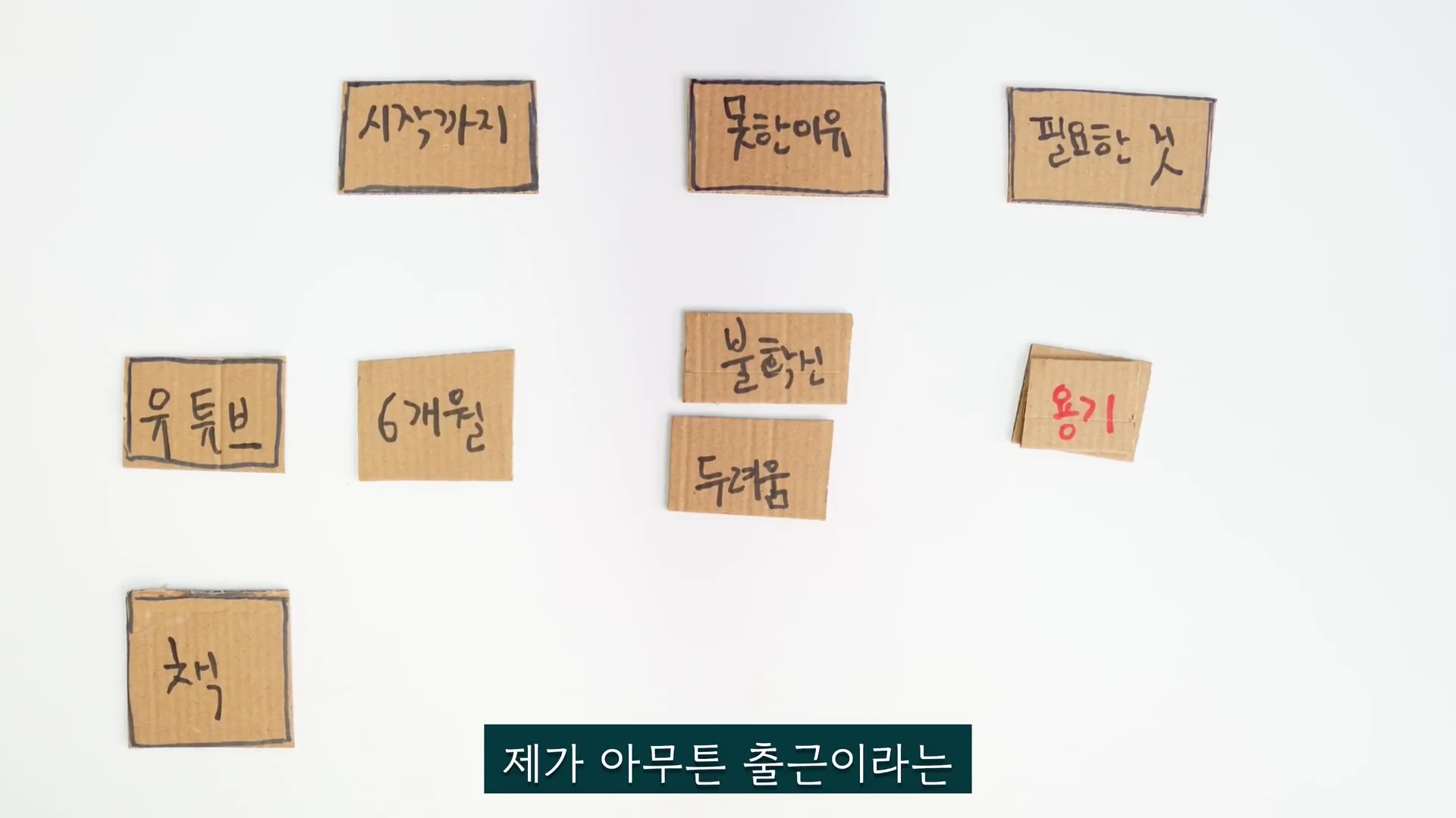 흰 배경 위에 시작하기, 못한 이유, 필요한 것, 유튜브, 6개월, 불확신, 두려움, 용기, 책이라고 손글씨로 적힌 작은 골판지 조각들이 나열되어 있다.