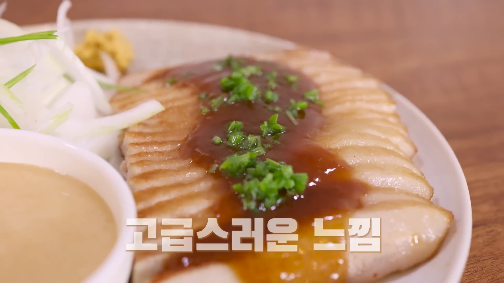 접시 위에 정갈하게 썰어 담긴 항정살 구이와 함께 미소 소스, 채 썬 양파가 놓여 있는 모습이다.