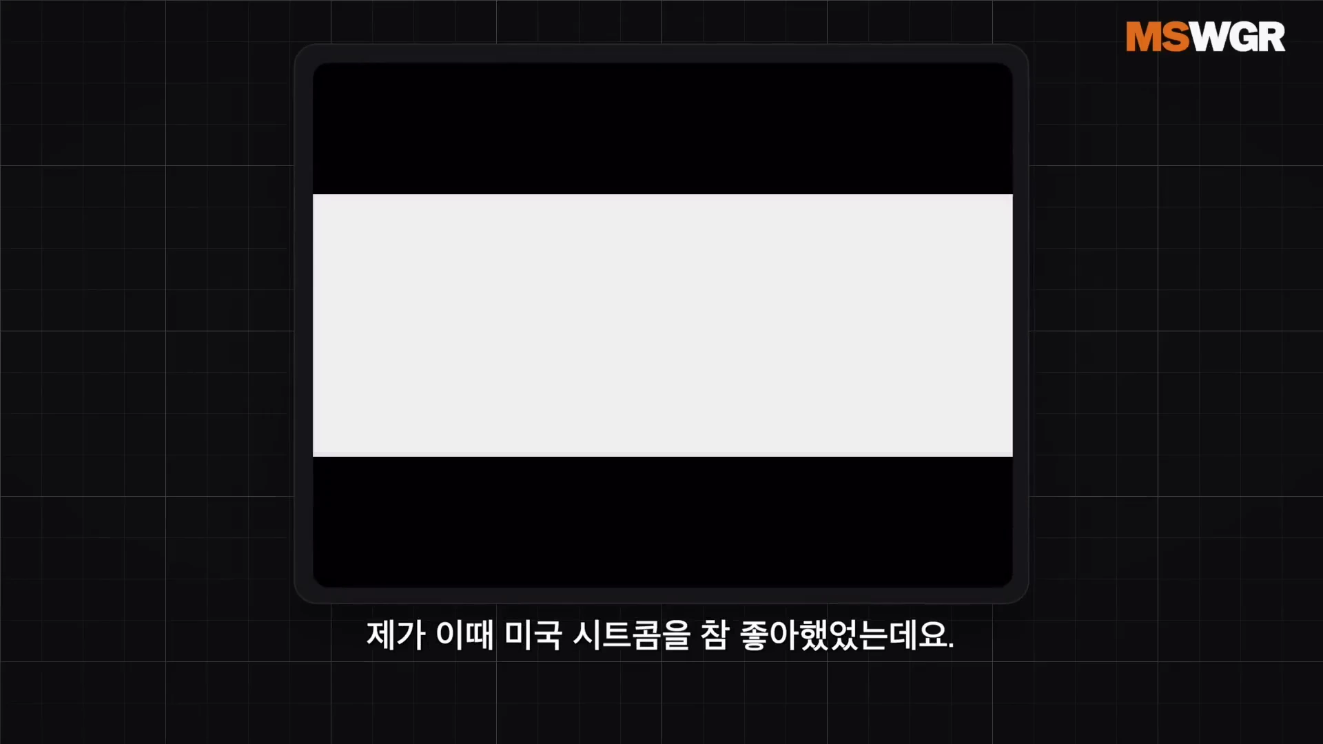 검은색 격자무늬 배경 중앙에 빈 사각형 프레임이 있고 하단에는 '제가 이때 미국 시트콤을 참 좋아했는데요.'라는 한국어 자막이 표시된 화면입니다.