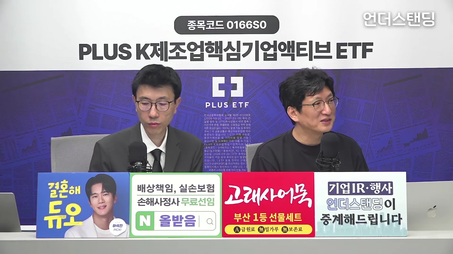 두 명의 남성이 스튜디오 테이블에 앉아 각자의 마이크 앞에 앉아 대화를 나누고 있다. 배경에는 'PLUS K제조업핵심기업액티브 ETF' 문구가 적힌 대형 스크린이 있고, 테이블 앞쪽에는 여러 기업 광고 패널이 붙어 있다.