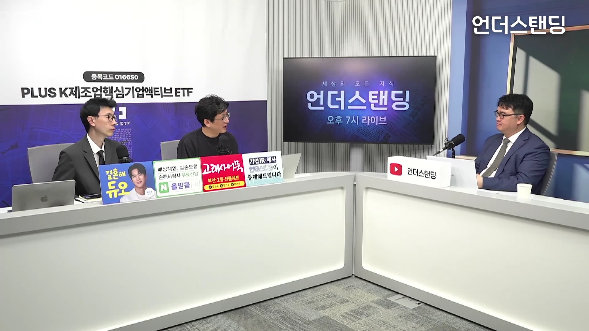 밝은 스튜디오에서 정장을 입은 진행자와 출연진 세 명이 테이블에 앉아 대화를 나누는 모습.