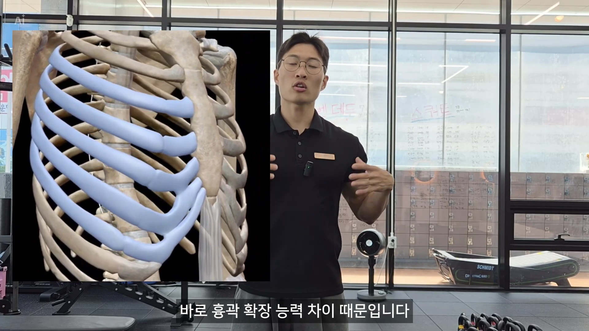 체육관 내에서 검은색 티셔츠를 입은 남성이 서서 설명하고 있으며, 화면 왼쪽에는 사람의 흉곽과 갈비뼈를 나타내는 3D 해부학 그래픽이 겹쳐져 있다.