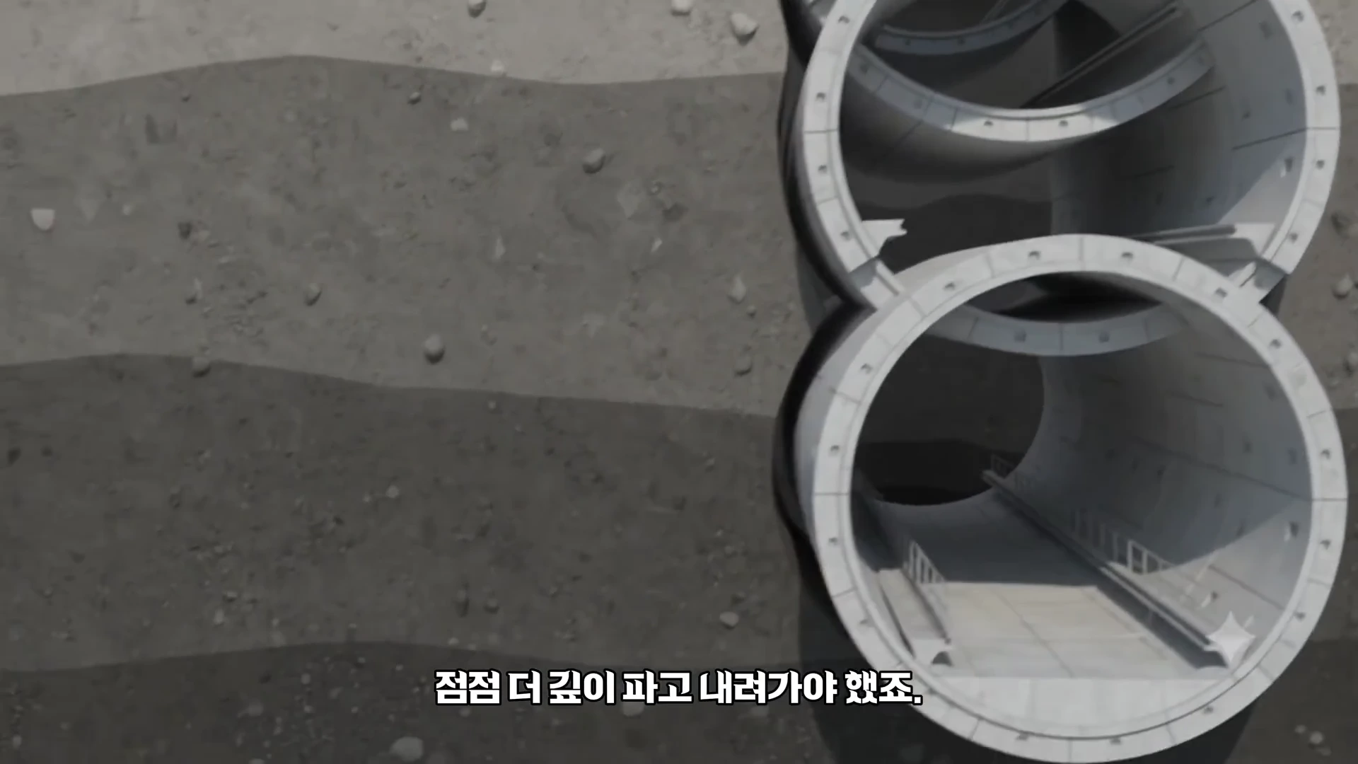 단면이 원형인 지하철 터널 구조물이 땅속에 묻혀 있는 모습을 보여주는 3D 그래픽 영상입니다.