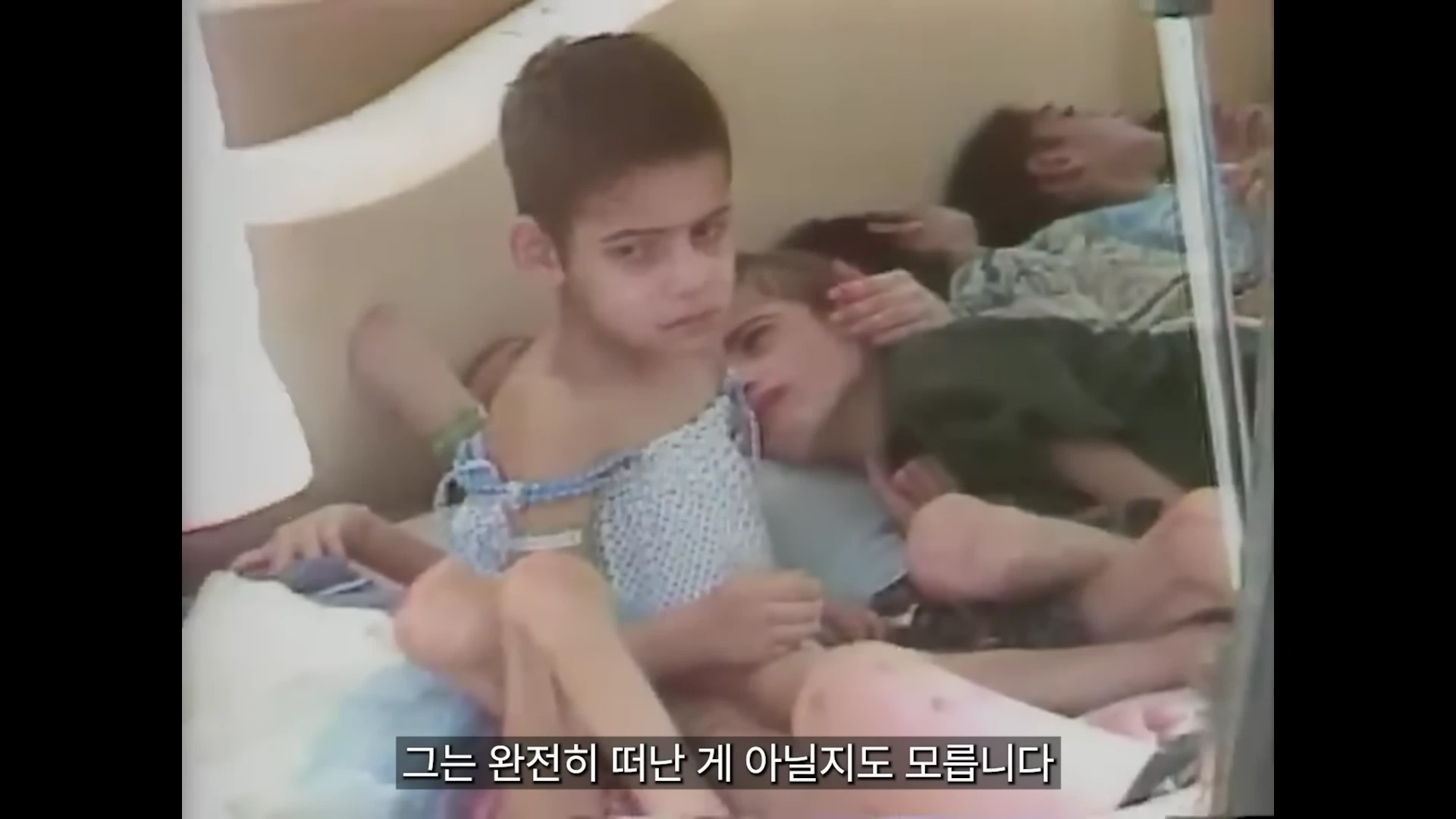 병원 침대에 누워 있는 어린아이들의 모습이 담긴 다큐멘터리 영상 화면